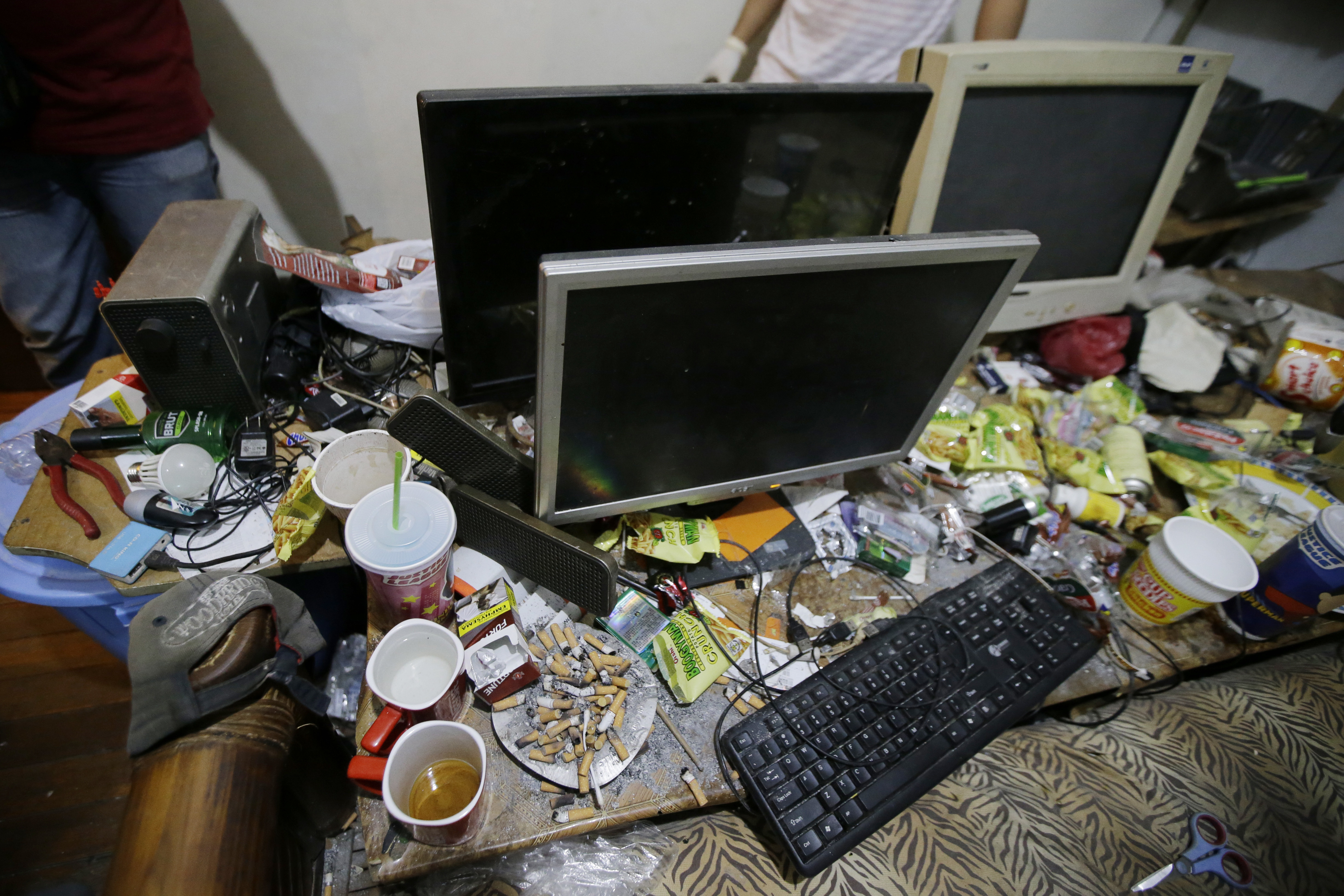 Food wrappers, cigarettes, plastic cups, perfume, and deodorant are spread across the workspace of suspected child webcam cybersex operator, David Timothy Deakin, from Peoria, Ill. Photo: AP Photo