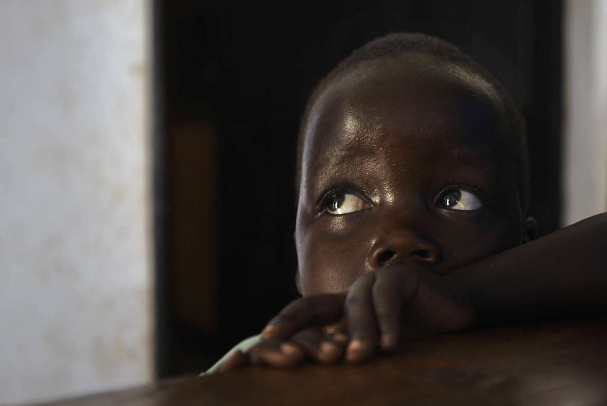 Daughter Betty, 3, looks up at her mother Adye Sunday, 25, unseen, who was abducted when she was 13 by Lord's Resistance Army (LRA) leader Joseph Kony. Photo: AP Photo