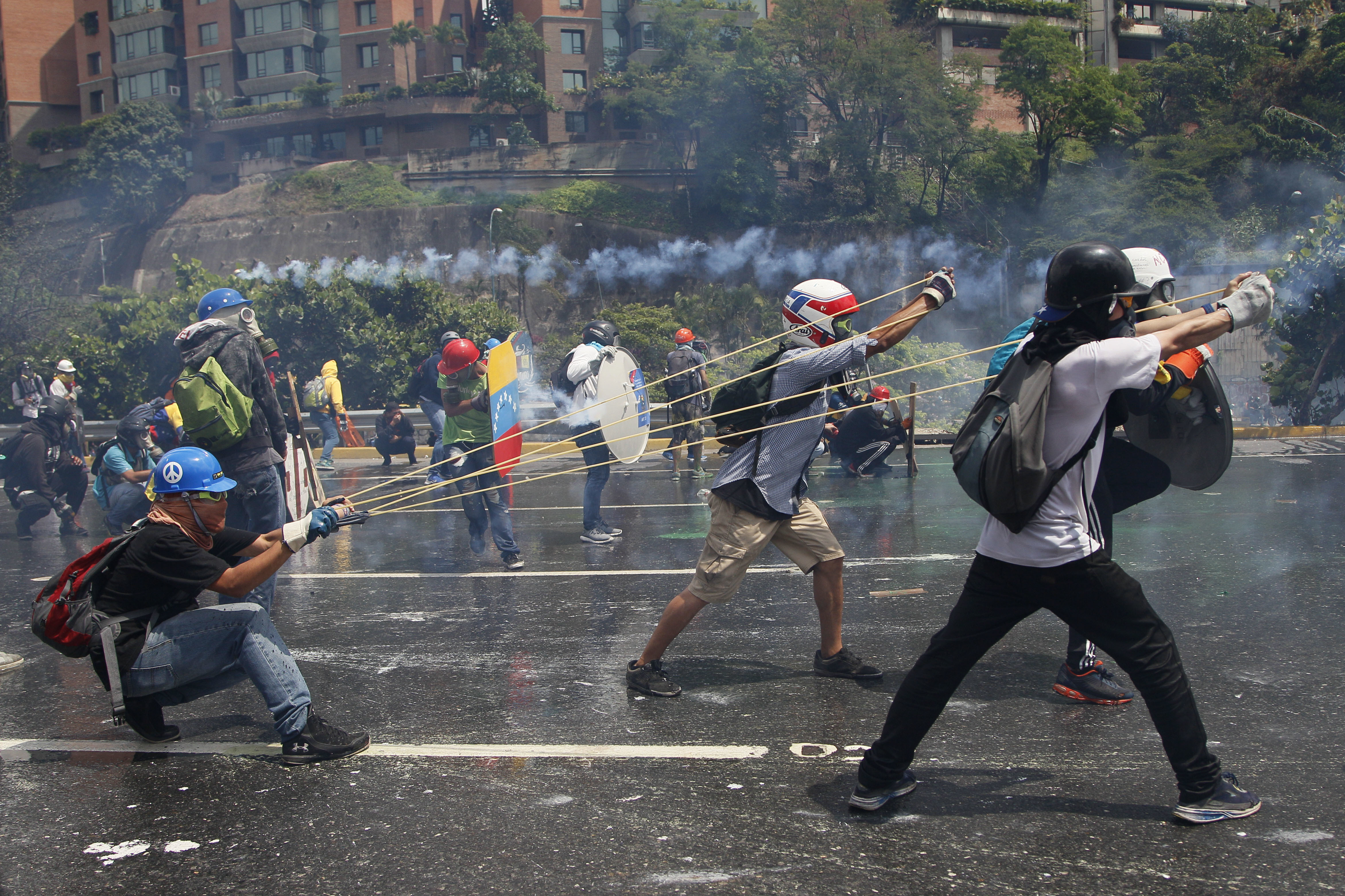 Venezuelans battle with shields, gas masks, fecal bombs