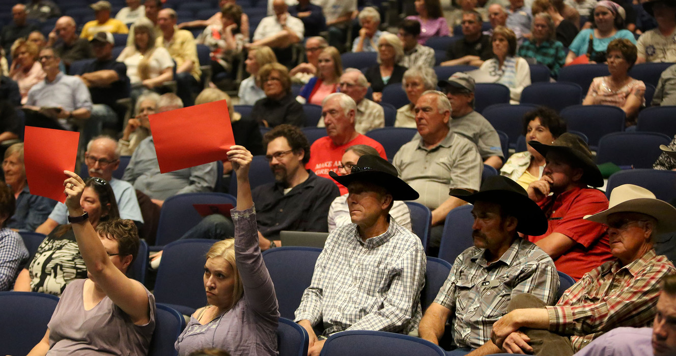 Tracie Parry, from West Valley City, and Nicole Peterson, who grew up in Richfield and now lives in Salt Lake City, hold up red paper to show that they disagree with Rep. Chris Stewart's claim that Planned Parenthood spent most of its money on abortions. (Photo: Kristin Murphy, Deseret News)