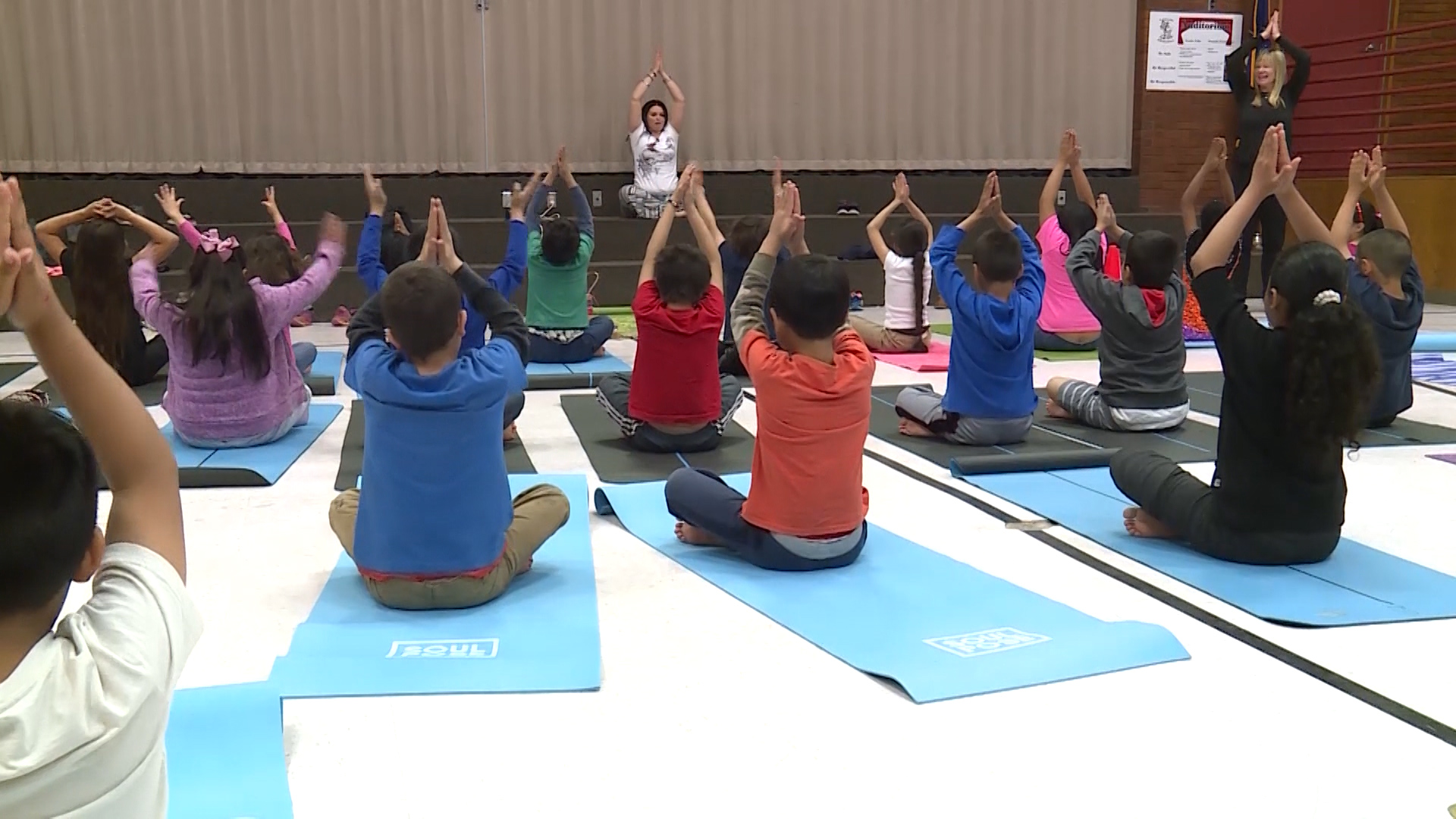 A diverse group of students participating in a school yoga program