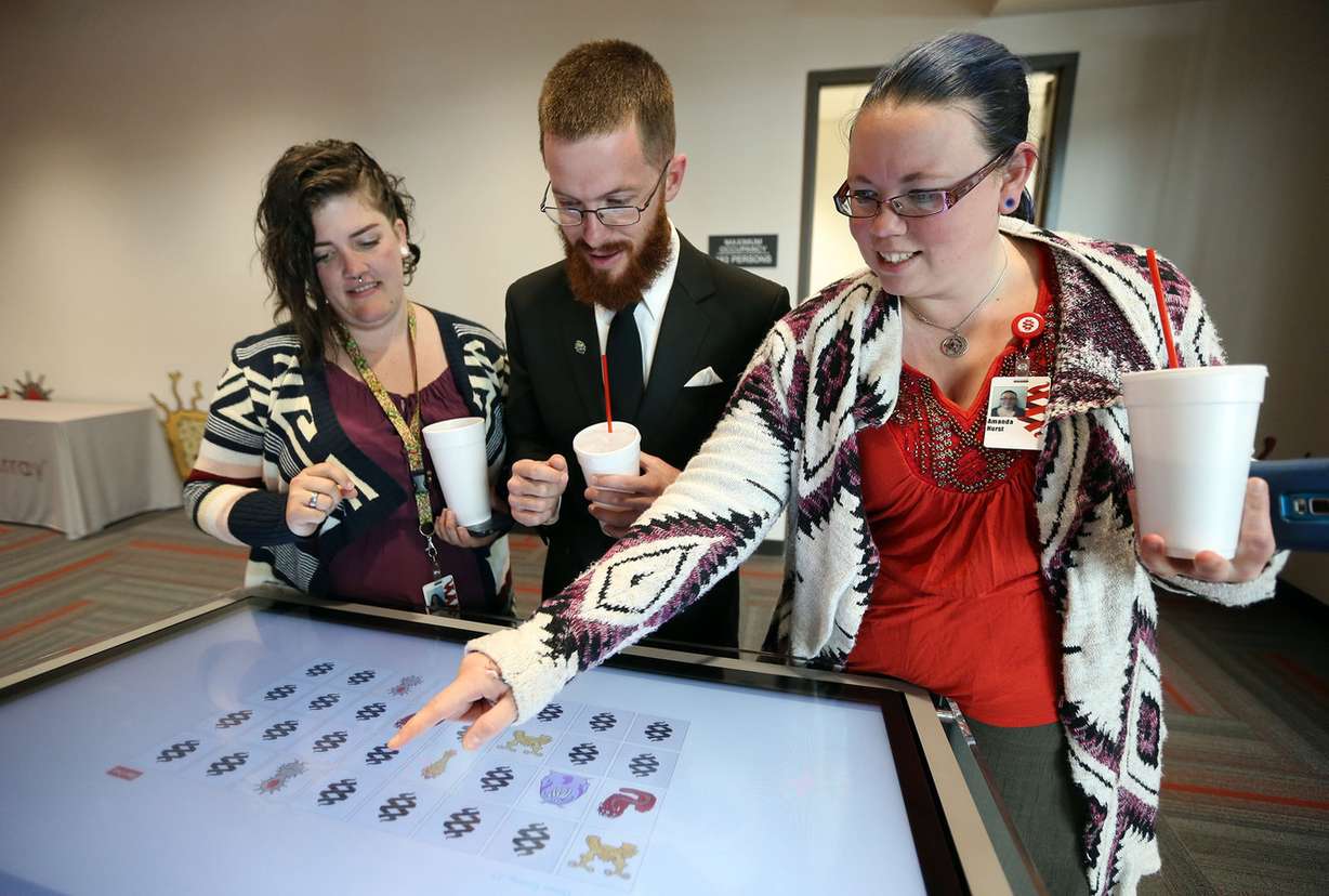 Jamie Wilcox, William Hurst and Amanda Hurst play a digital germ memory game at the dedication of the Alain Mérieux Center for Molecular Diagnostics in Salt Lake City on Wednesday, May 17, 2017. (Photo: Kristin Murphy, Deseret News)