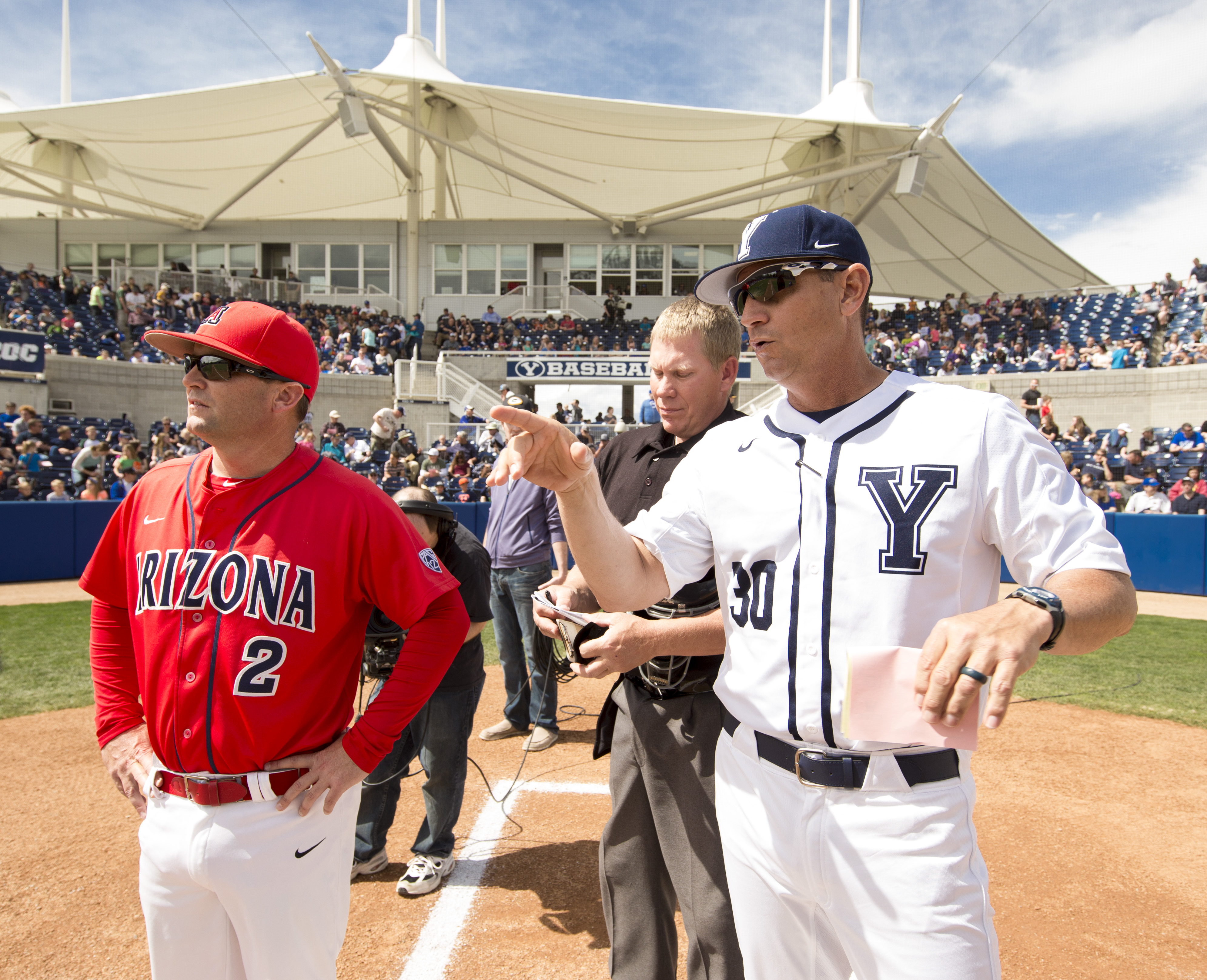 BYU coach Mike Littlewood meets at home plate before a game against Arizona in 2017.