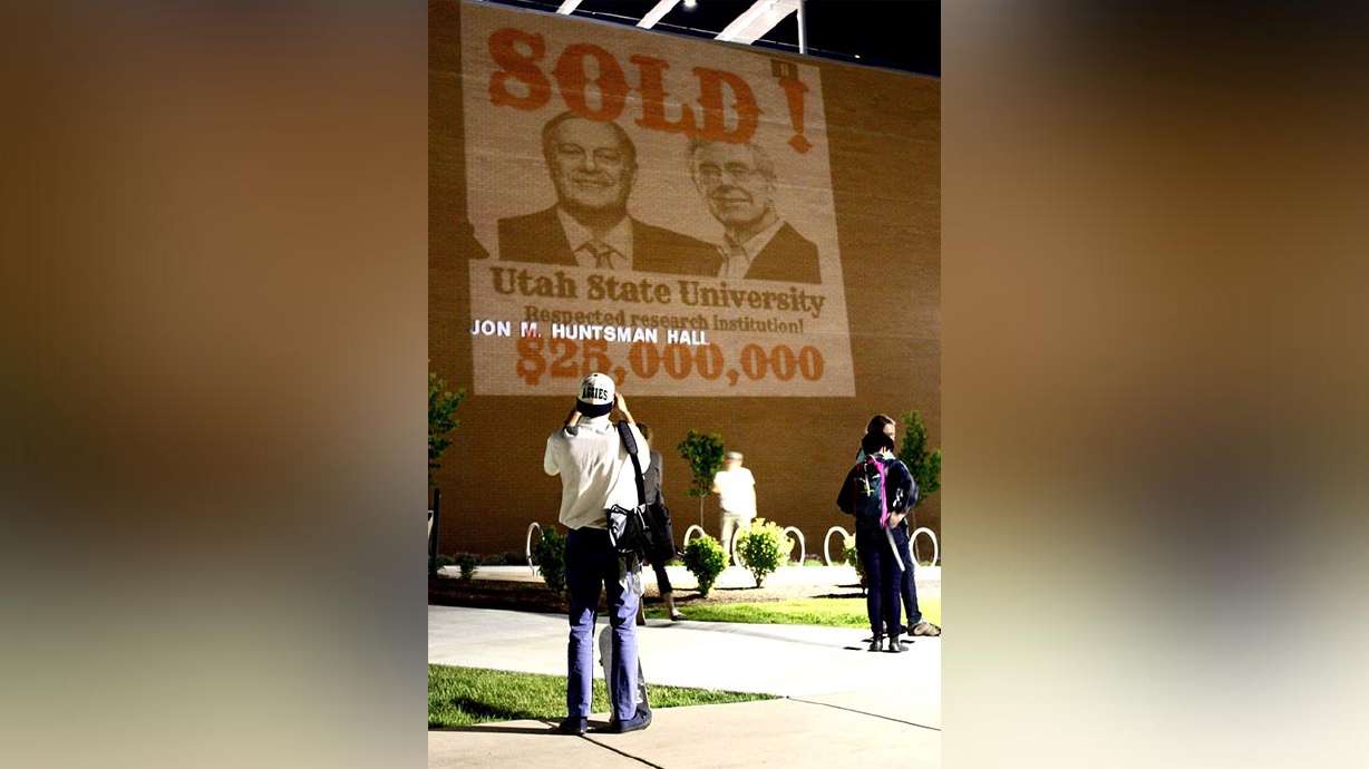 SOLD! sign projected on USU business school to protest $25M gift from Koch Foundation