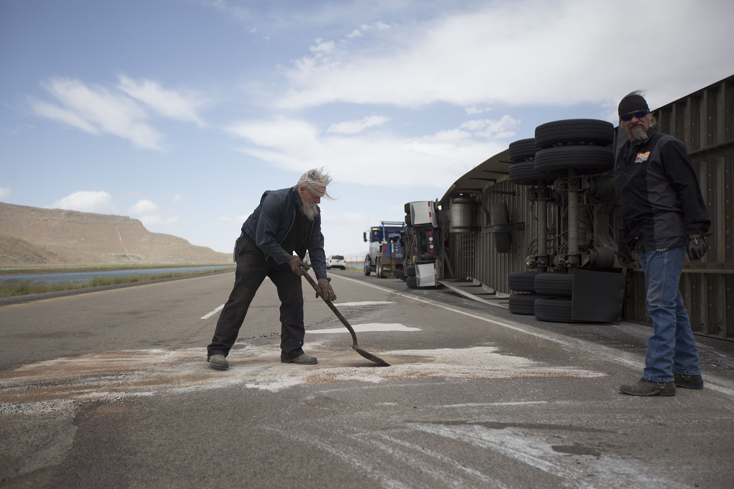 Bob Williams and Kenny Phillips clean the road after a semitrailer was toppled by the wind on I-80 near Dugway on Monday, June 12, 2017. (Photo: Kelsey Brunner, Deseret News)