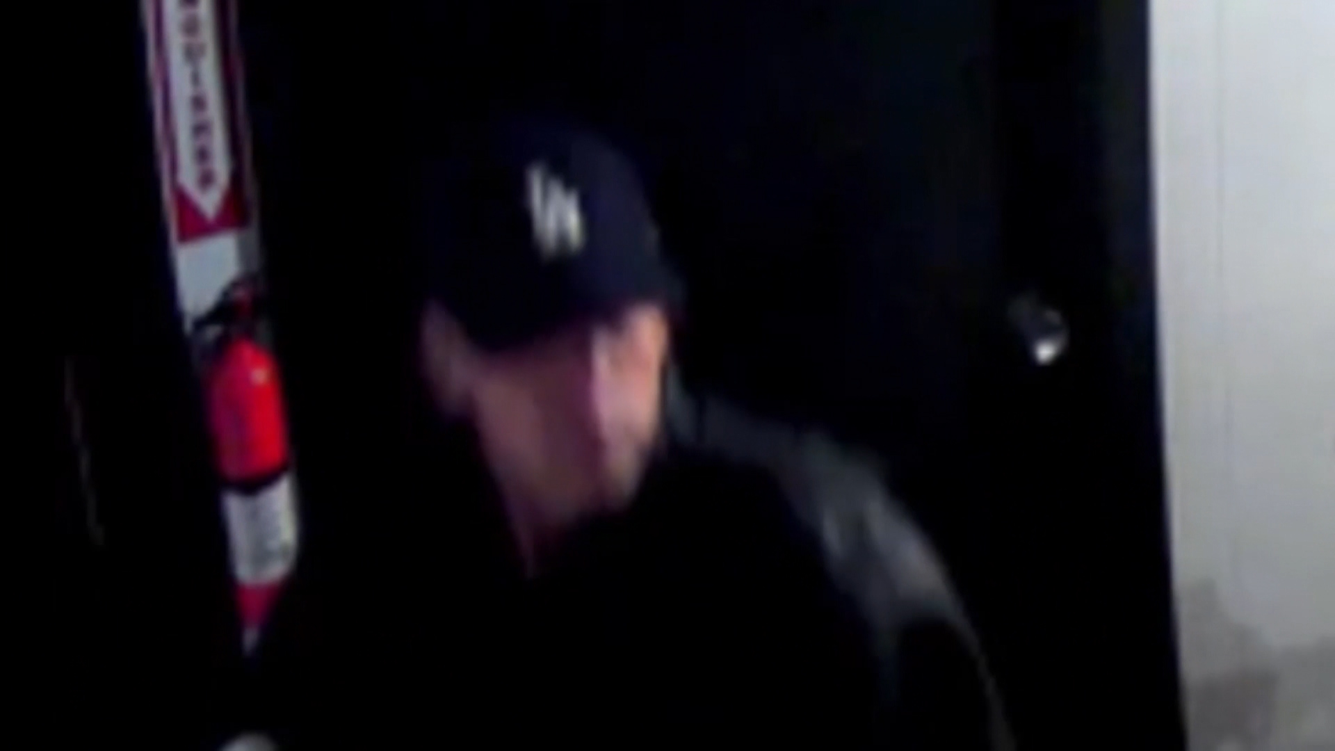 Surveillance video shows a man walking into a photography business Sunday night and immediately yelling in Spanish before punching one of the two people inside. (Security footage)