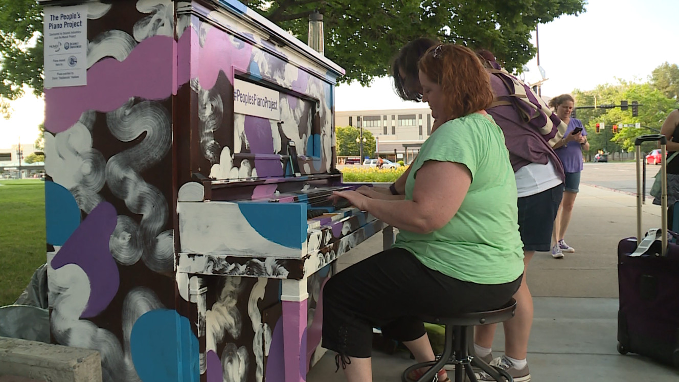 Two passers-by sit down at a piano in Salt Lake City on Wednesday, June 21, 2017, and start playing "Chopsticks" together. (Photo: Steve Breinholt, KSL TV)