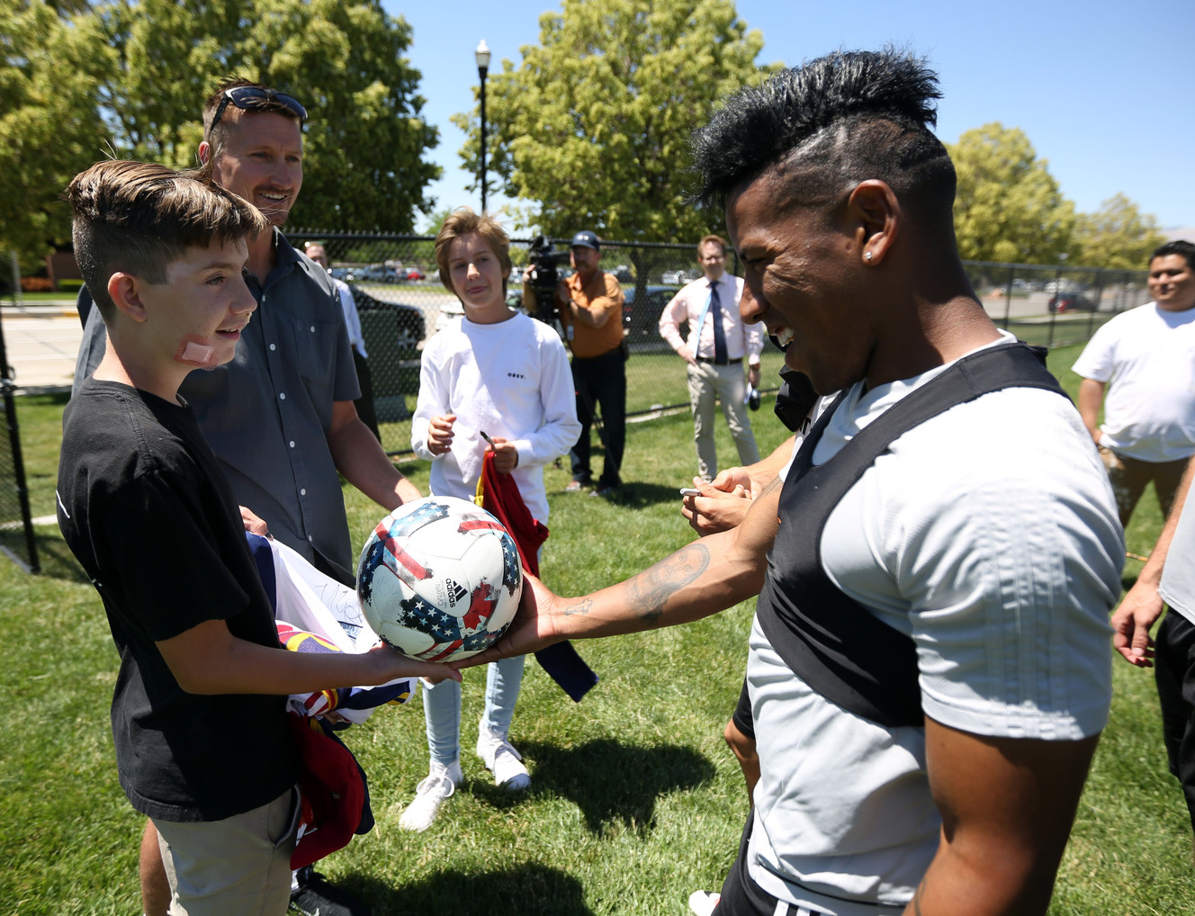 Real Salt Lake forward Joao Plata gives a soccer ball to Myles Rackley after practice in Sandy on Thursday, June 22, 2017. Myles, 11, was injured June 6 in a shooting that left his mother and younger brother dead. (Photo: Kristin Murphy, Deseret News)