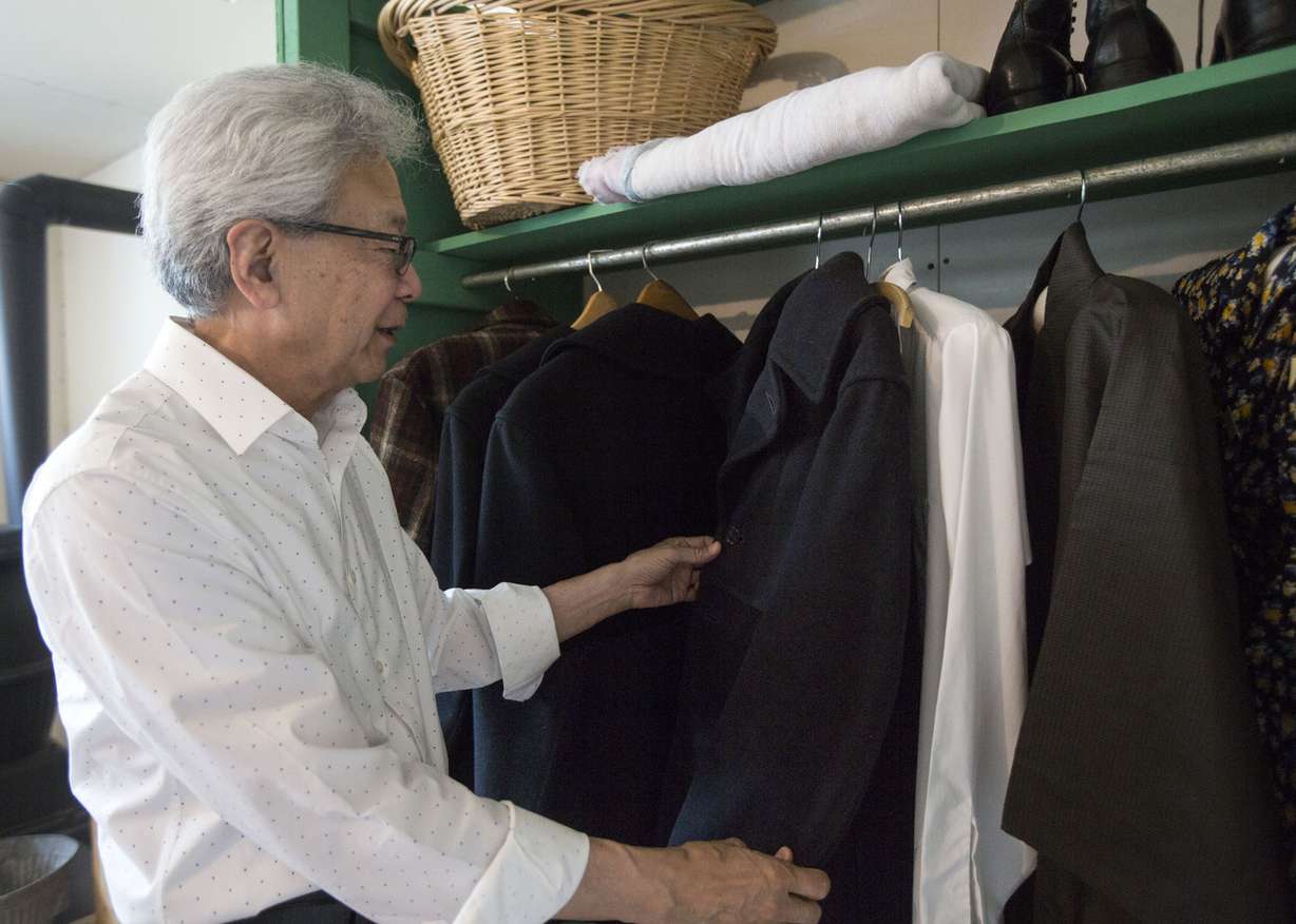 Hisashi Sugaya takes his dad's old pea coat from a museum display of a home in the internment camp on the opening weekend of the new Topaz Museum in downtown Delta on Friday, July 7, 2017. The pea coat was given to Sugaya's father when he first entered the camp and Sugaya recently donated it to be displayed in the museum. (Photo: Kelsey Brunner, Deseret News)