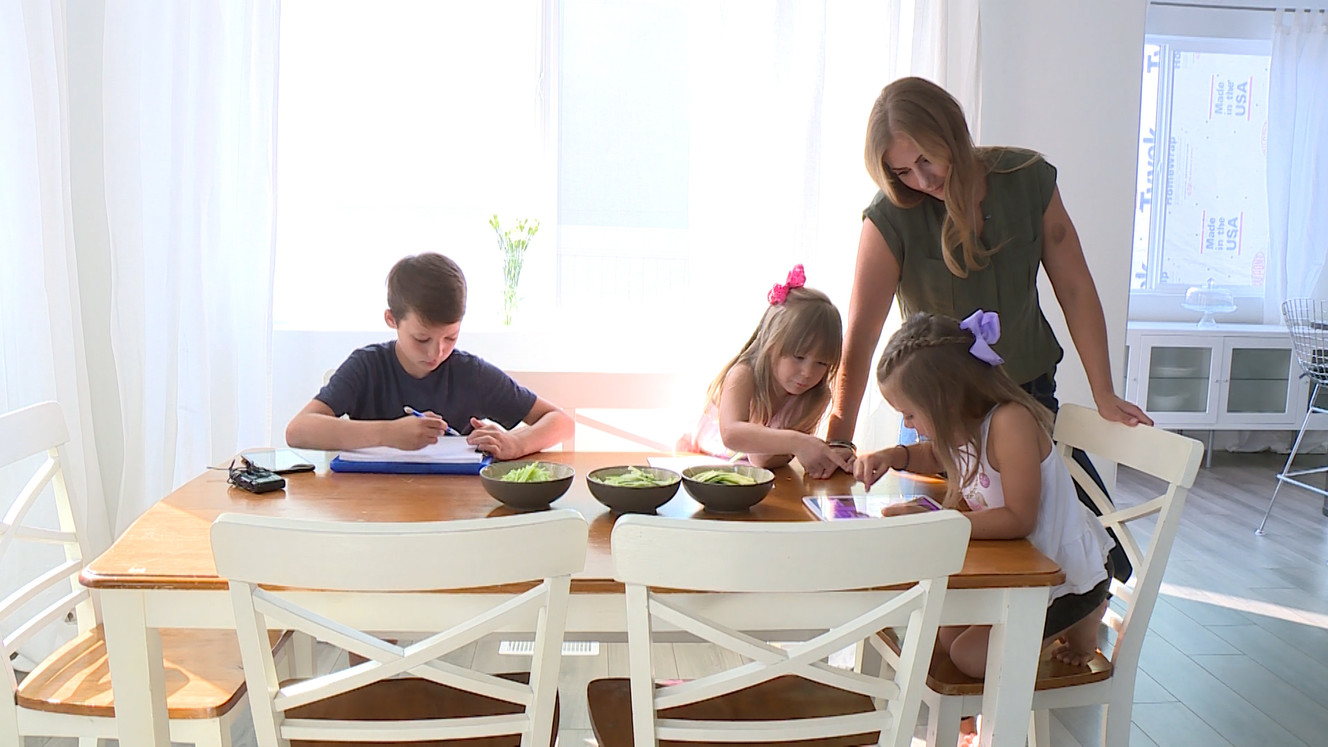 Whitney Gomez takes a moment to check out a video game her children are playing on a tablet. (Photo: Ray Boone, KSL TV)