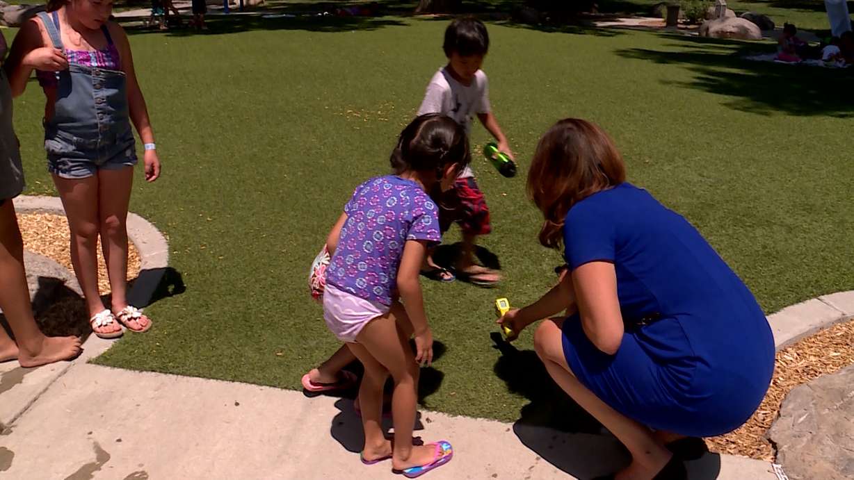 KSL Investigator Debbie Dujanovic measures the temperature of the artificial turf at Liberty Park in Salt Lake City. She got consistent readings over 175 degrees Fahrenheit. (Photo: KSL TV)