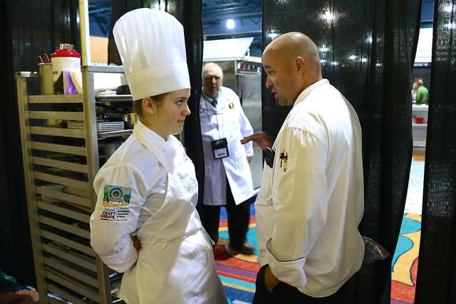A judge talks with Utah Valley University culinary student Madeline Black during the American Culinary Federation Cook. Craft. Create. national convention on July 8-13 in Orlando, Florida. Black was named the National Student Chef of the Year after making a winning dish including truffle-scented duck roulade finished in duck fat, with Utah honey lacquered duck thigh-riblet. (Photo: Ashley Stilson)