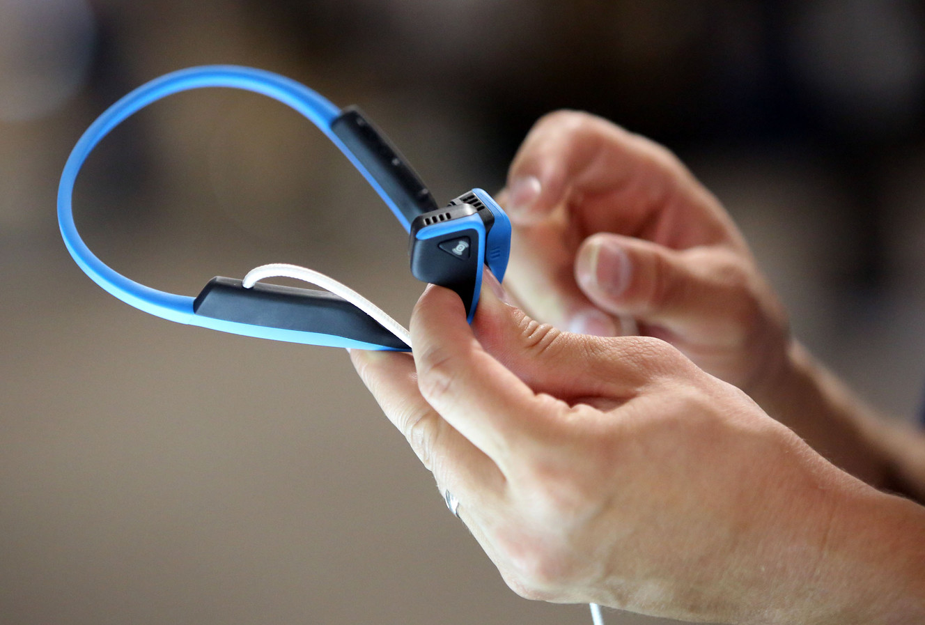 Sam Scholes demos a pair of AfterShokz bone conduction headphones at the Outdoor Retailer show in pavilion tent near the Salt Palace Convention Center in Salt Lake City on Thursday, July 27, 2017. (Photo: Kristin Murphy, Deseret News)