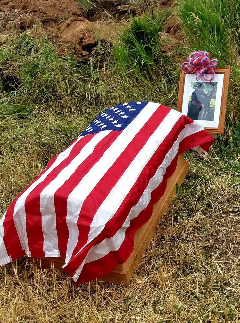 A photo of Duchesne County Sheriff's Cpl. Morant Harrison and his K-9 partner Q, sits behind the dog's flag-draped casket during a memorial service Tuesday, Aug. 1, 2017. Q was medically retired in July following a terminal cancer diagnosis. (Photo: Duchesne County Sheriff's Office)