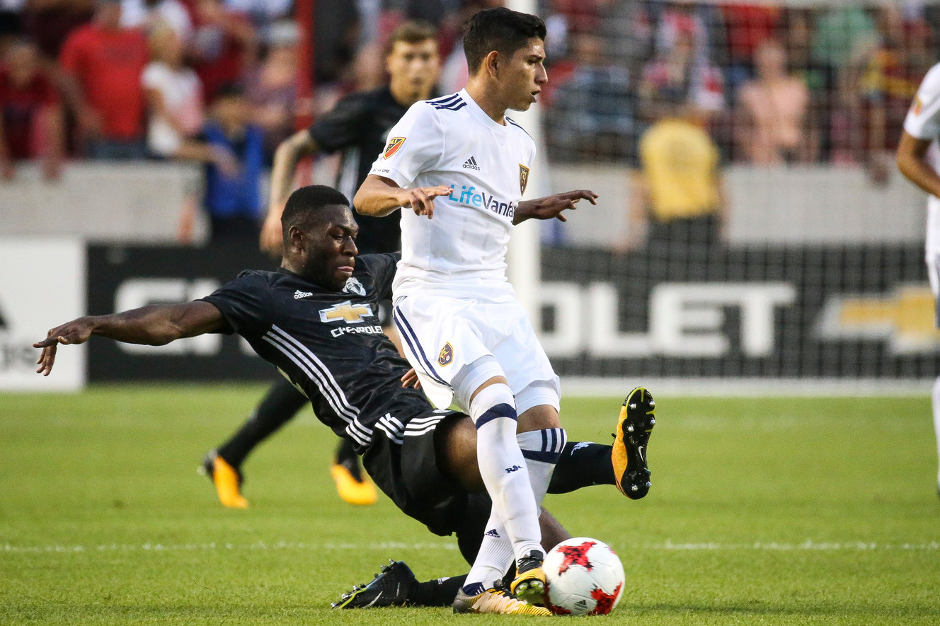 Manchester United defender Timothy Fosu-Mensah (24) slides into Real Salt Lake midfielder Jefferson Savarino during a match at Rio Tinto Stadium in Sandy on Monday, July 17, 2017. (Photo: Spenser Heaps, Deseret News)