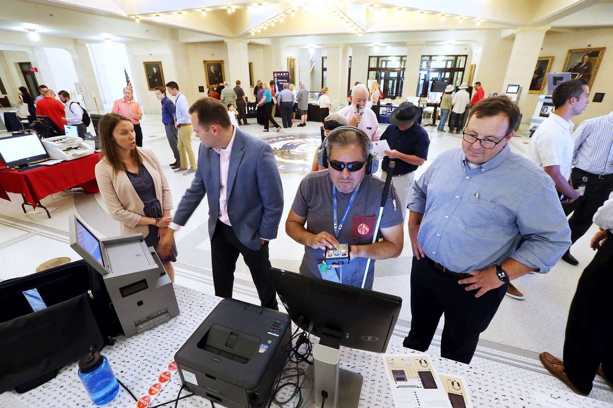 Nick Rios, center, who is visually impaired, tries out Clear Ballot's voting system as the company's Chris Hanna, right, looks on at the state Capitol in Salt Lake City on Wednesday, Aug. 2, 2017. (Photo: Scott G Winterton, Deseret News)