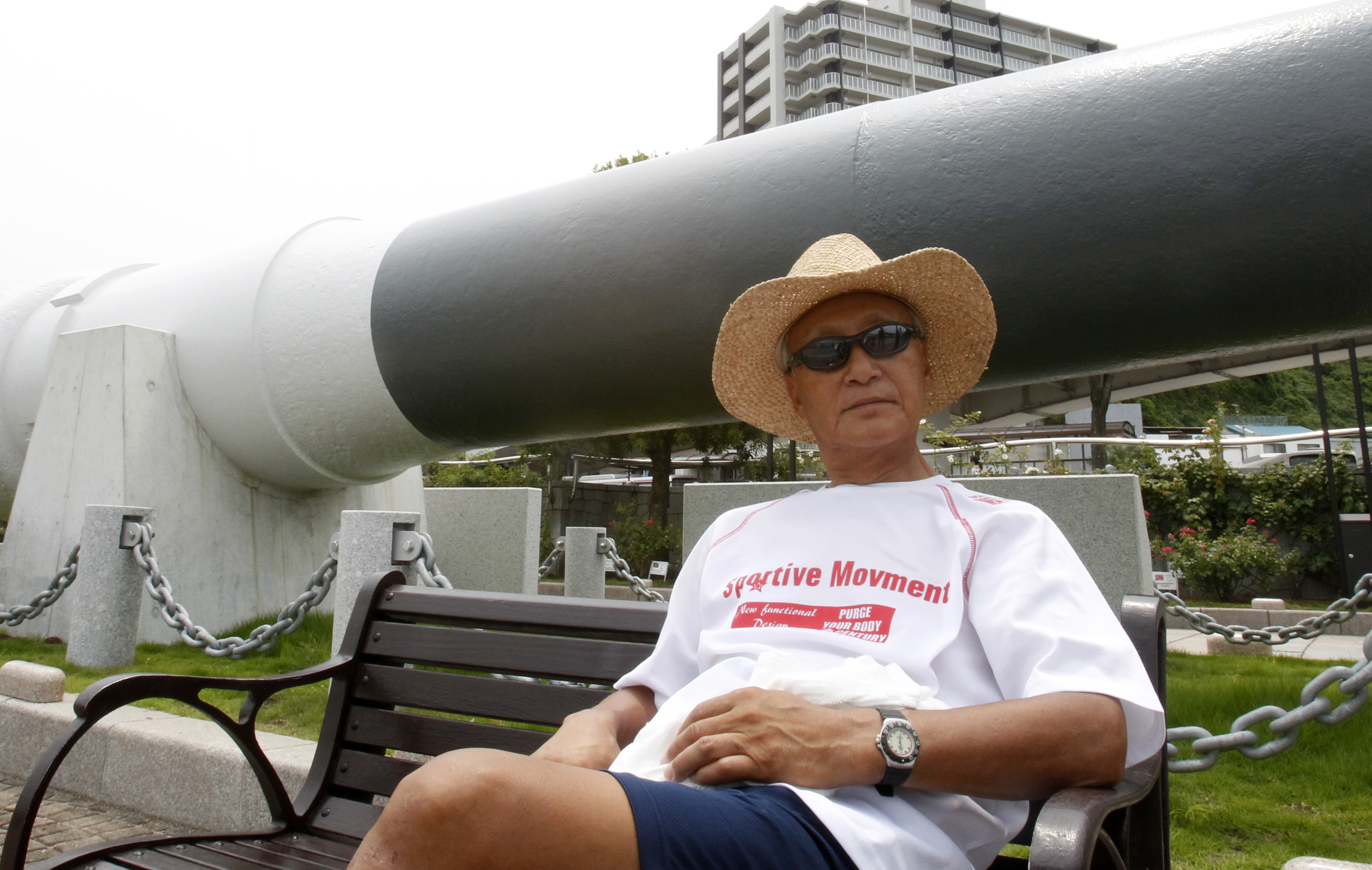 In this Tuesday, Aug. 1, 2017, photo, Akira Fukatsu, a 65-year-old retiree, sits in front of a replica cannon in Verny Park in Yokosuka, south of Tokyo. Photo: AP Photo