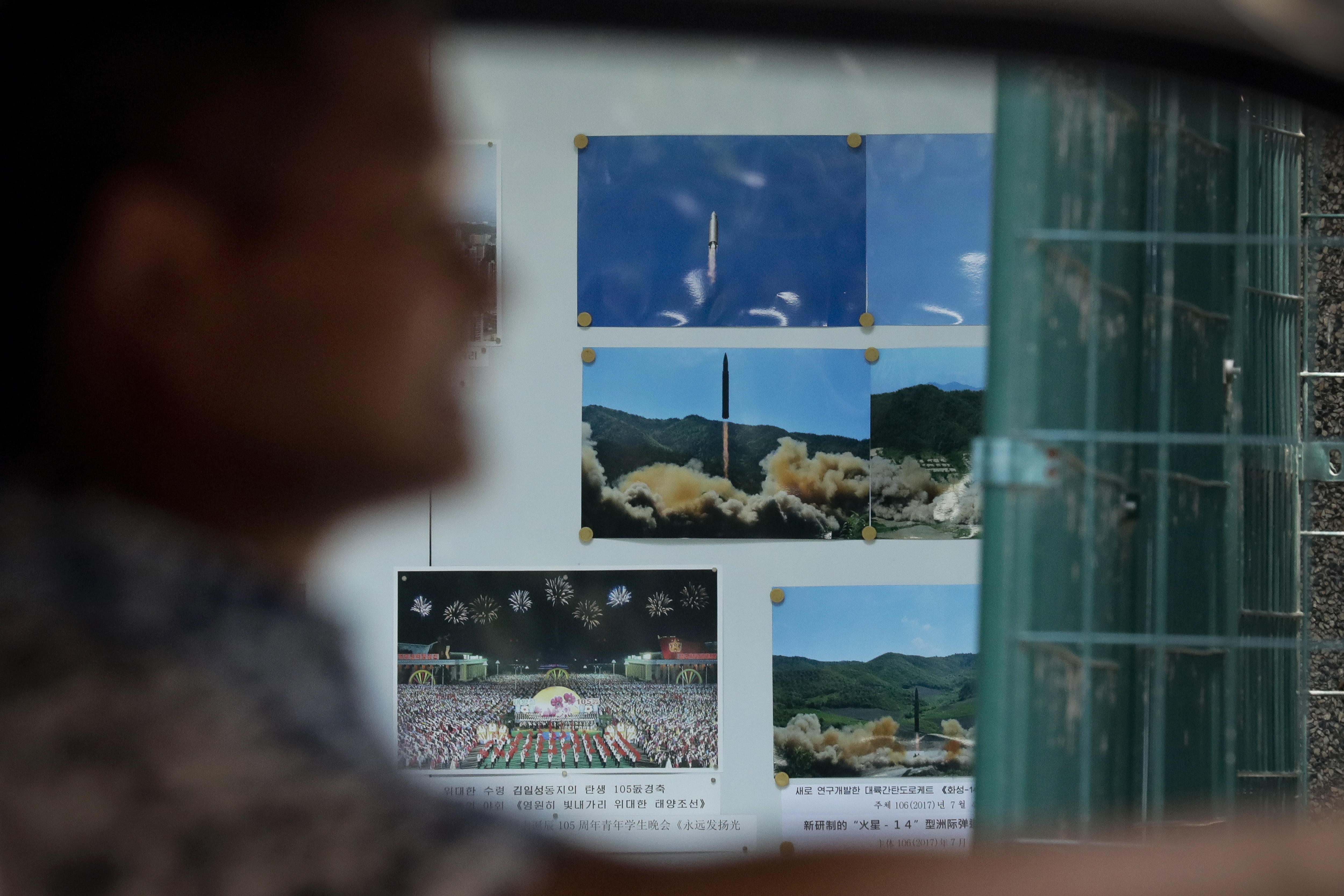 A man drives his car past a display board showing photos of ballistic missile launches in North Korea outside the North Korean Embassy in Beijing, Thursday, Aug. 3, 2017. Photo: AP Photo