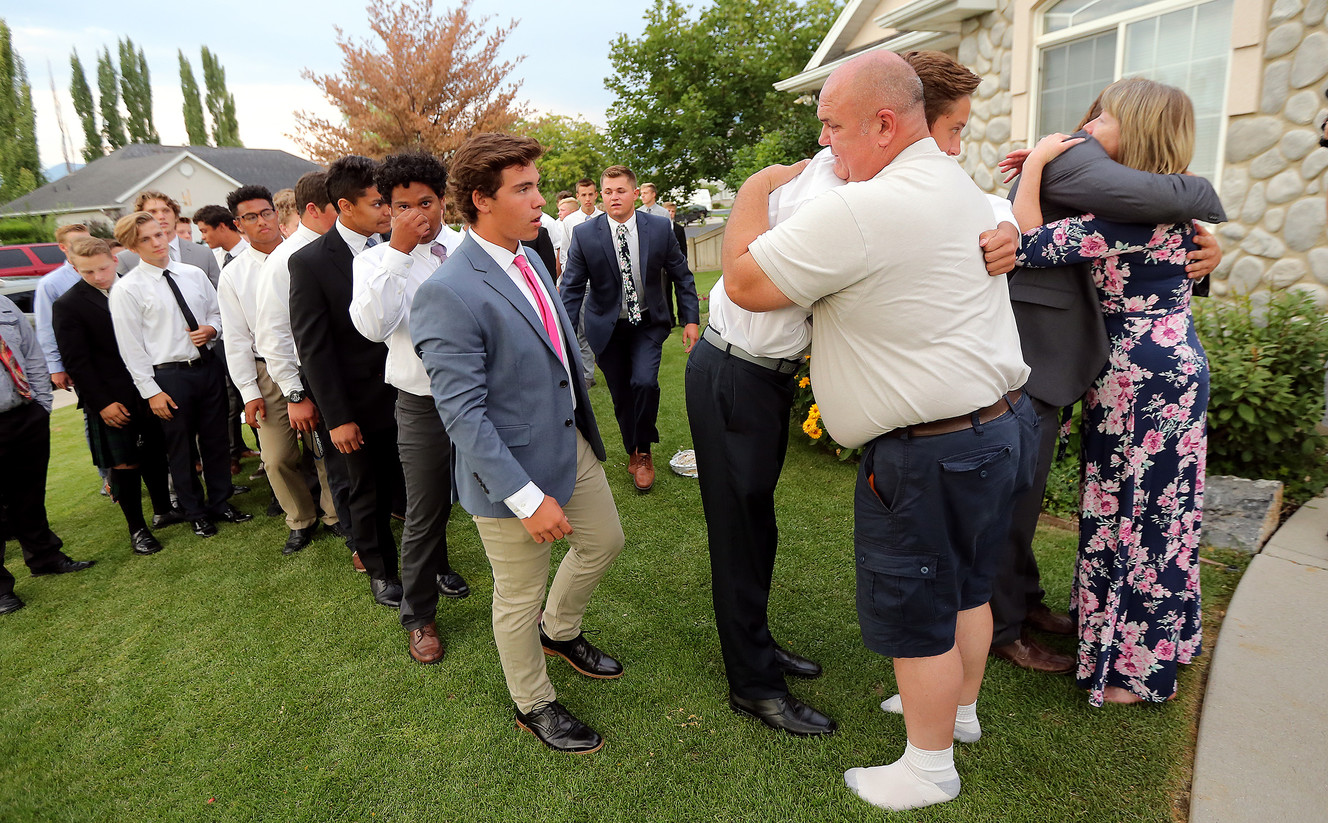 Doug and Tracy Julian hug members of the Salem Hills High School football team after they sang "Nearer, My God to Thee" on the front lawn of their Woodland Hills home on Sunday, Aug. 6, 2017. The couple's son, also named Doug, died Saturday of apparent altitude sickness while on a Boy Scout outing in the High Uintas. He was also a member of the football team. (Photo: Scott G Winterton, Deseret News)