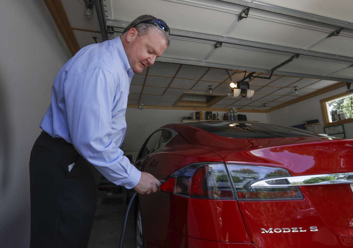 In this Thursday, July 13, 2017, photo, Jeff Solie plugs in his electric Tesla sedan at his home, in New Berlin, Wis. Photo: AP Photo