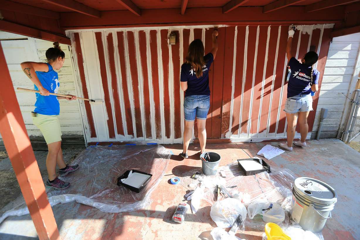 U.S. Bank employees and folks from NeighborWorks Salt Lake paint a home in Salt Lake City as part of the organization's annual Paint Your Heart Out event on Friday, Aug. 11, 2017. (Photo: Scott G Winterton, Deseret News)