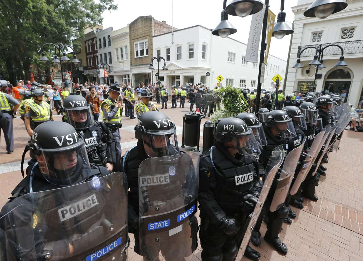 FILE- Virginia State Police cordon off an area around the site where a car ran into a group of protesters after a white nationalist rally in Charlottesville, Va., Saturday, Aug. 12, 2017. (Steve Helber, AP Photo, File)