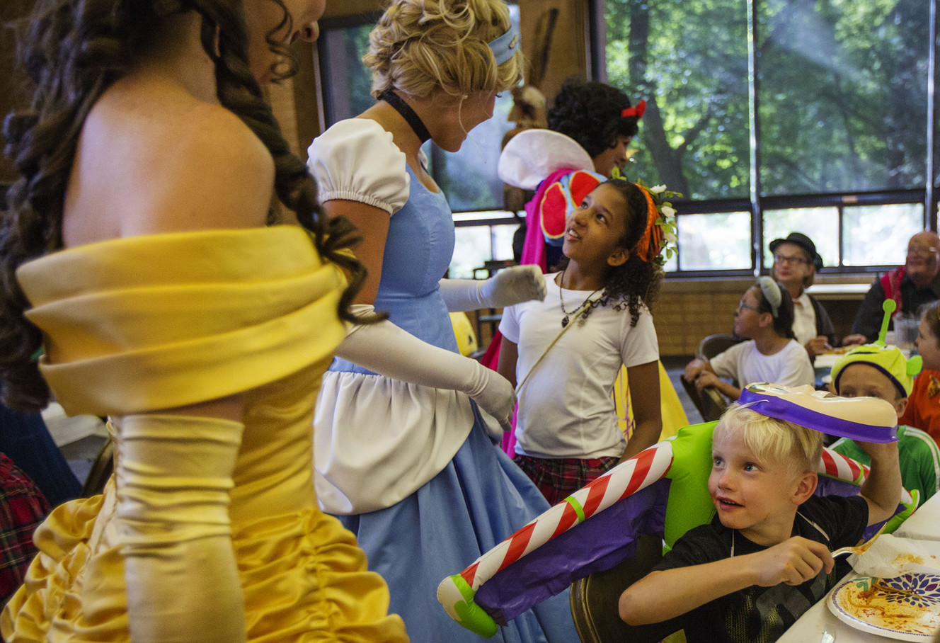 Camdon Johnson, 7, right, shyly turns around during his meal to find princesses behind him at the burn camp's Disney-themed red carpet event in Salt Lake City on Sunday, Aug. 13, 2017. (Photo: Kelsey Brunner, Deseret News)