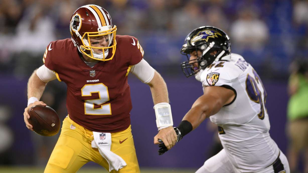 Washington Redskins quarterback Nate Sudfeld, left, tries to outrun Baltimore Ravens defensive end Bronson Kaufusi in the second half of a preseason NFL football game, Thursday, Aug. 10, 2017, in Baltimore.