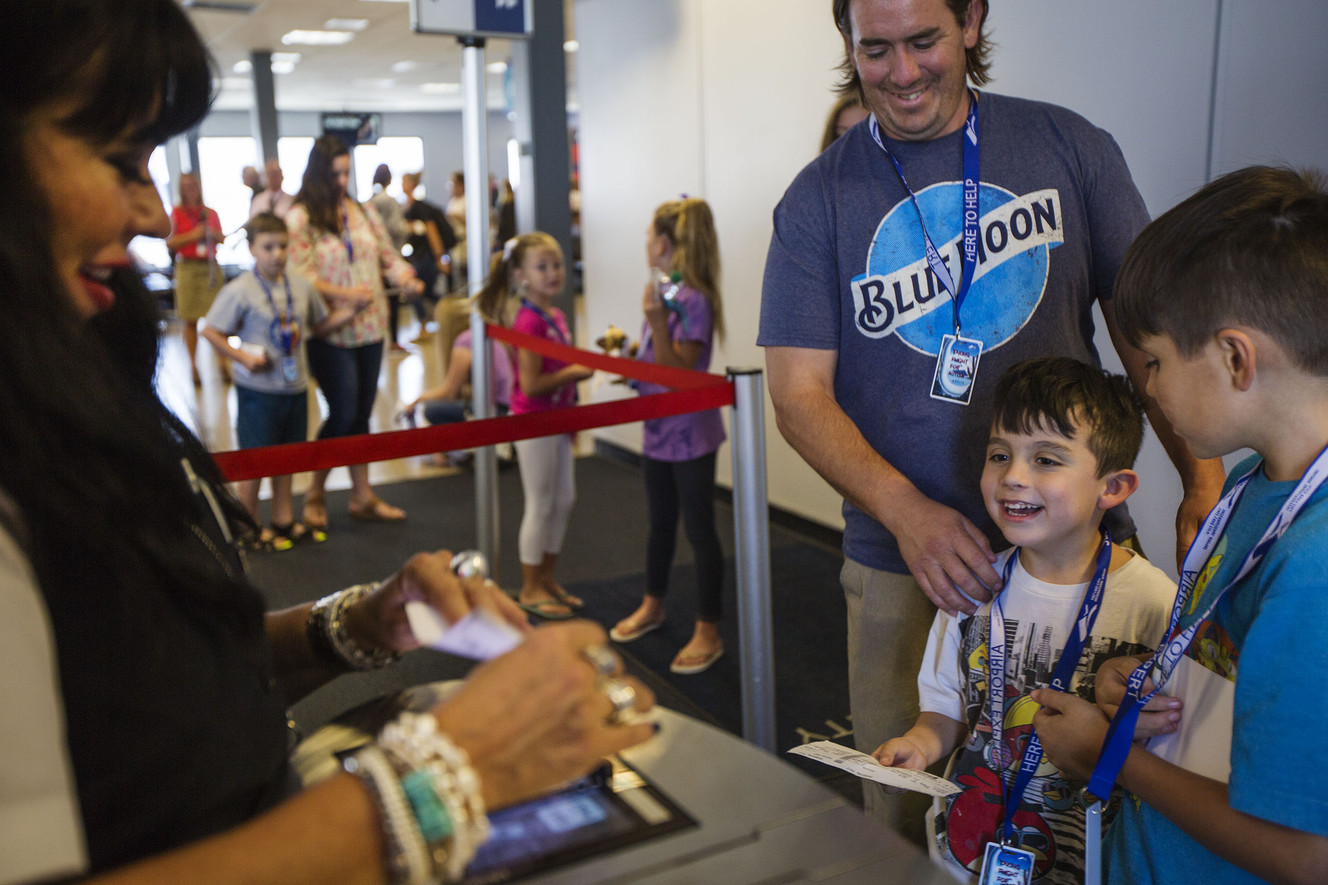 A Delta employee checks in Jason Fryer, center, and his two sons, Troy Fryer, 6, and Abram Fryer, 10, at a Delta gate during the Taking Flight for Autism event at the Salt Lake City International Airport in Salt Lake City on Thursday, Aug. 17, 2017. (Photo: Kelsey Brunner, Deseret News)