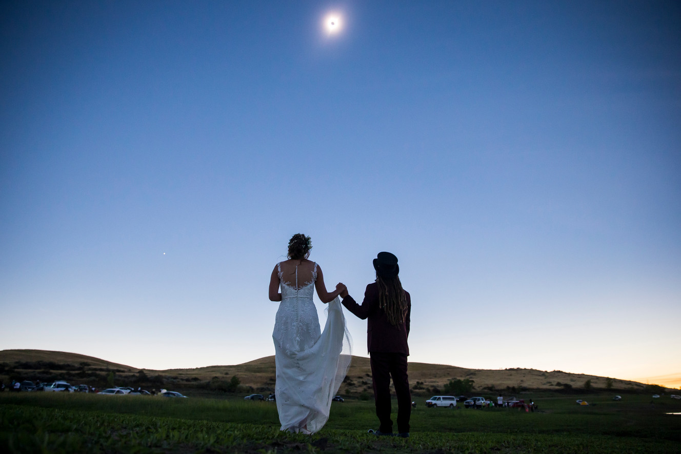 Elien Wijns, left, of Brussels, Belgium, and Liam Dorney, of Brisbane, Australia, take in the total solar eclipse at Mann Creek Reservoir near Weiser, Idaho, on their wedding day, Monday, Aug. 21, 2017.(Photo: Spenser Heaps, Deseret News)