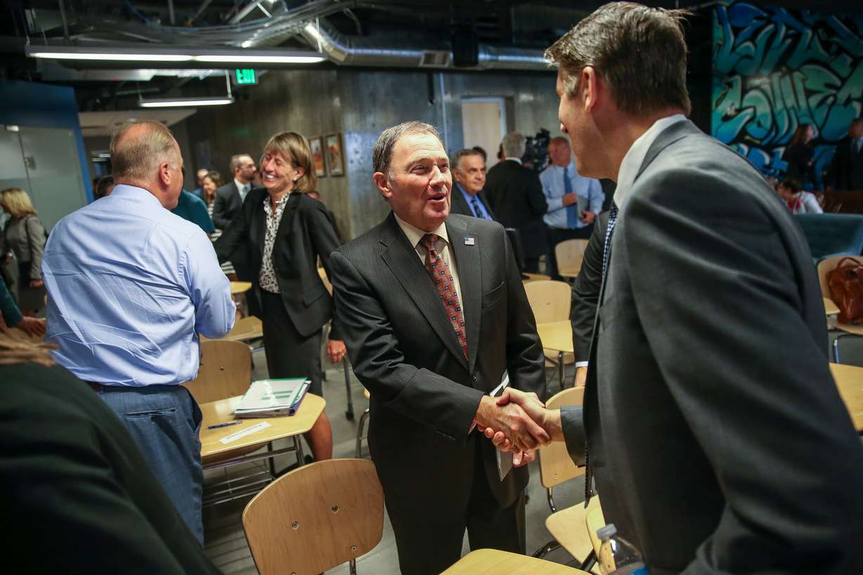 Gov. Gary Herbert, center, greets Matthew S. Holland, president of Utah Valley University, at the Silicon Slopes headquarters in Lehi on Wednesday, Aug. 23, 2017. (Photo: Spenser Heaps, Deseret News)