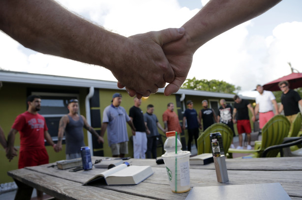 In this Thursday, July 6, 2017 photo, recovering addicts join hands during a meeting at Recovery Boot Camp, in Delray Beach, Fla. Photo: AP Photo