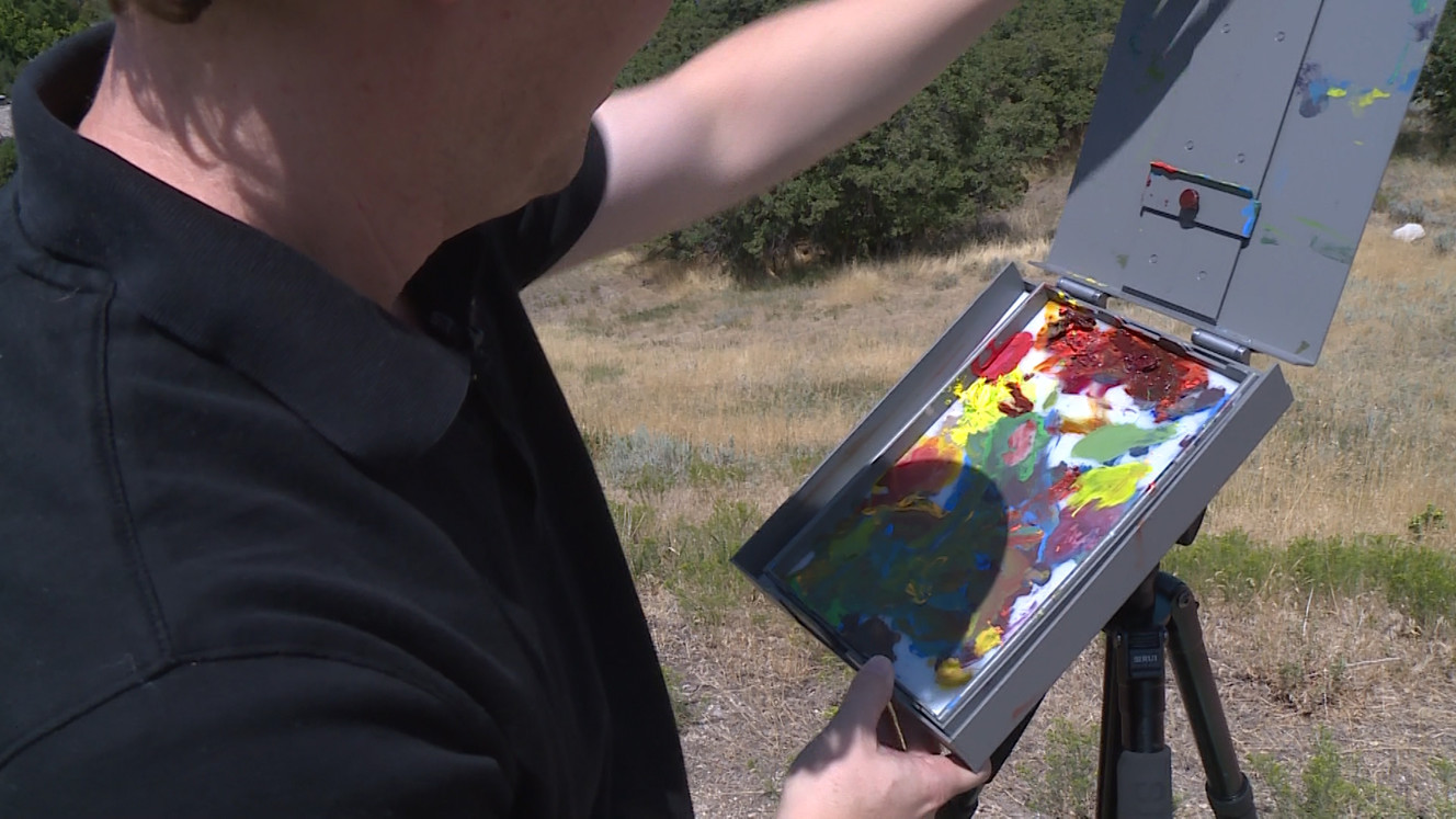 Bryan Mark Taylor and his easel are pictured on Tuesday, Aug. 15, 2017. He was determined to design an easel that was durable enough to not be damaged on his travels, but light enough to tote around. (Photo: Ray Boone)