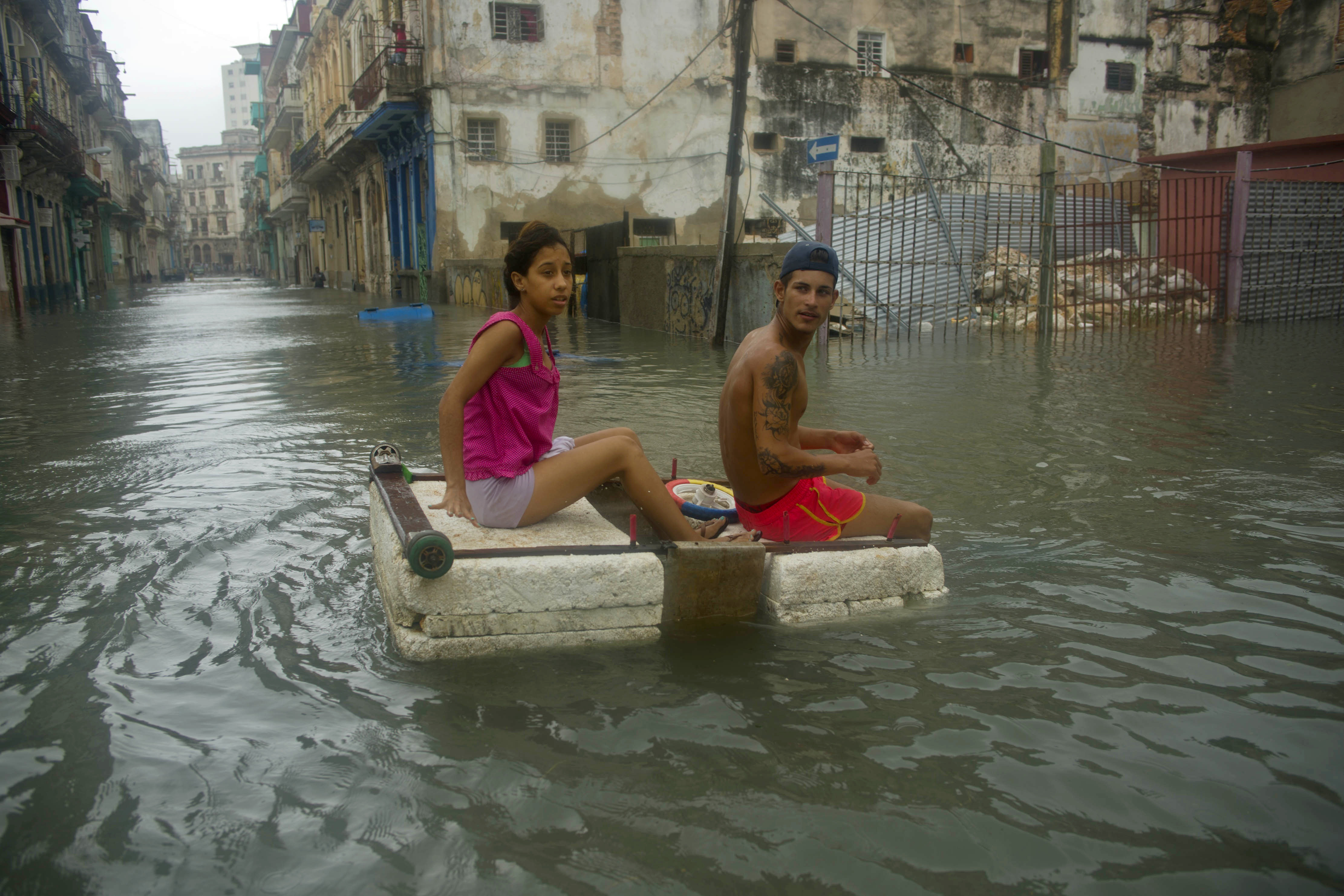 A couple floats down a flooded street in Havana atop a large piece of styrofoam, after the passing of Hurricane Irma in Cuba, Sunday, Sept. 10, 2017. The powerful storm ripped roofs off houses, collapsed buildings and flooded hundreds of miles of coastline after cutting a trail of destruction across the Caribbean.There were no immediate reports of deaths in Cuba, a country that prides itself on its disaster preparedness, but authorities were trying to restore power and clear roads. (AP Photo/Ramon Espinosa)