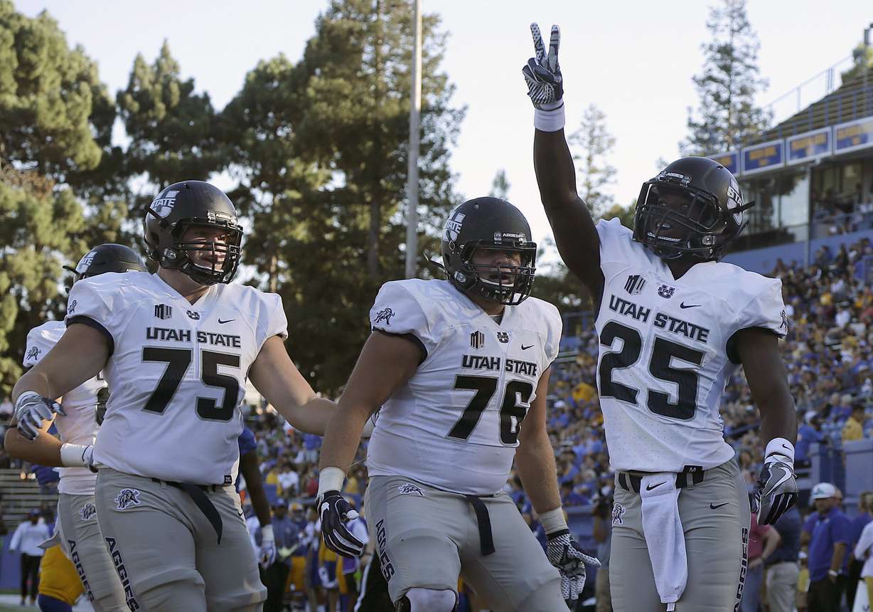 Utah State wide receiver Gerold Bright (25) celebrates after scoring a touchdown with Ty Shaw (75) and Roman Andrus during the first half of an NCAA college football game against San Jose State in San Jose, Calif., Saturday, Sept. 23, 2017. (Photo: Jeff Chiu, AP)