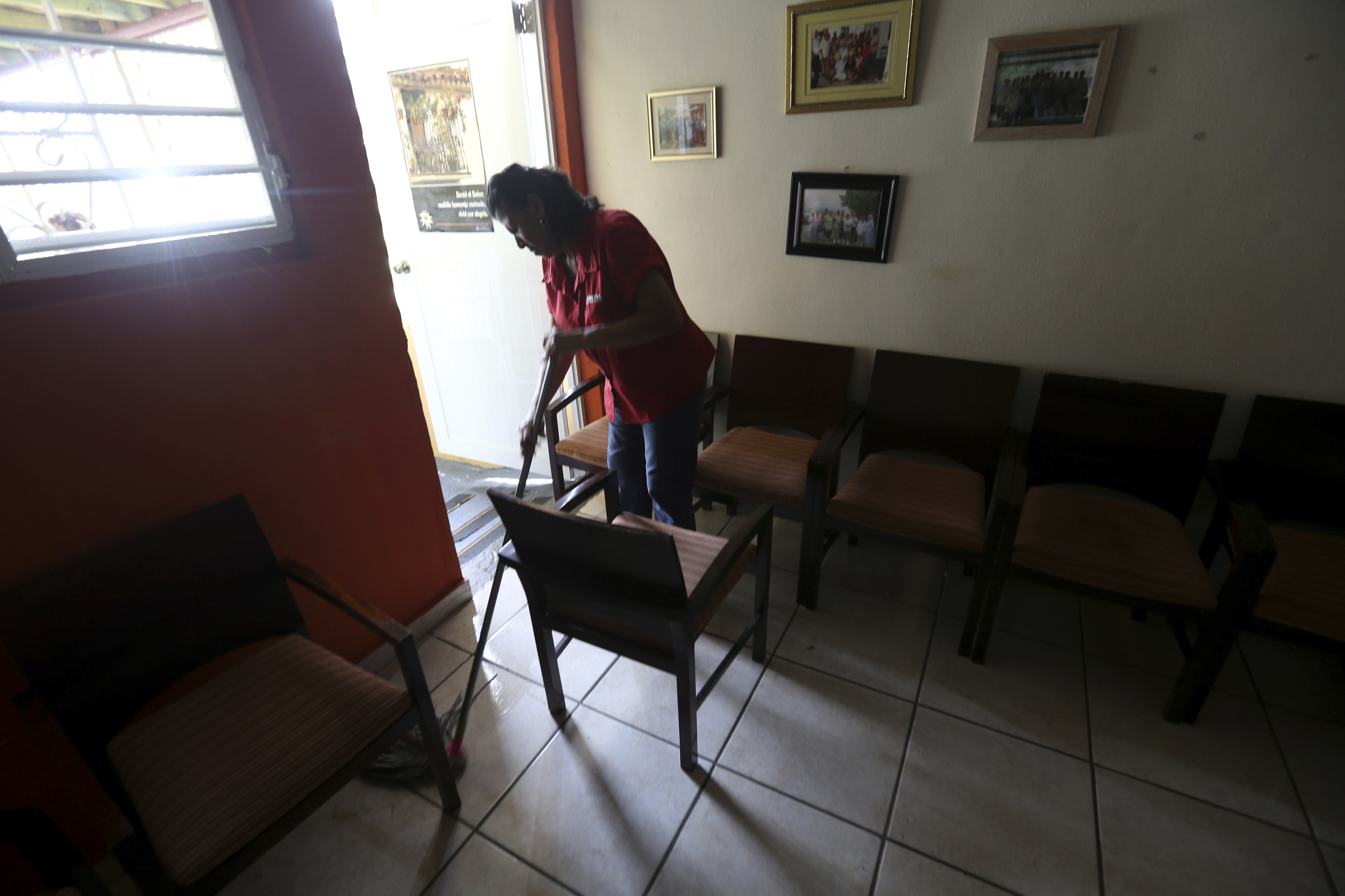 Dalia Rojas mops the floor of the senior care facility "Caritas de San Juan," with the help of daylight as much of Puerto Rico deals without electricity in the aftermath of Hurricane Maria, in San Juan, Puerto Rico, Monday, Sept. 25, 2017. Photo: AP Photo
