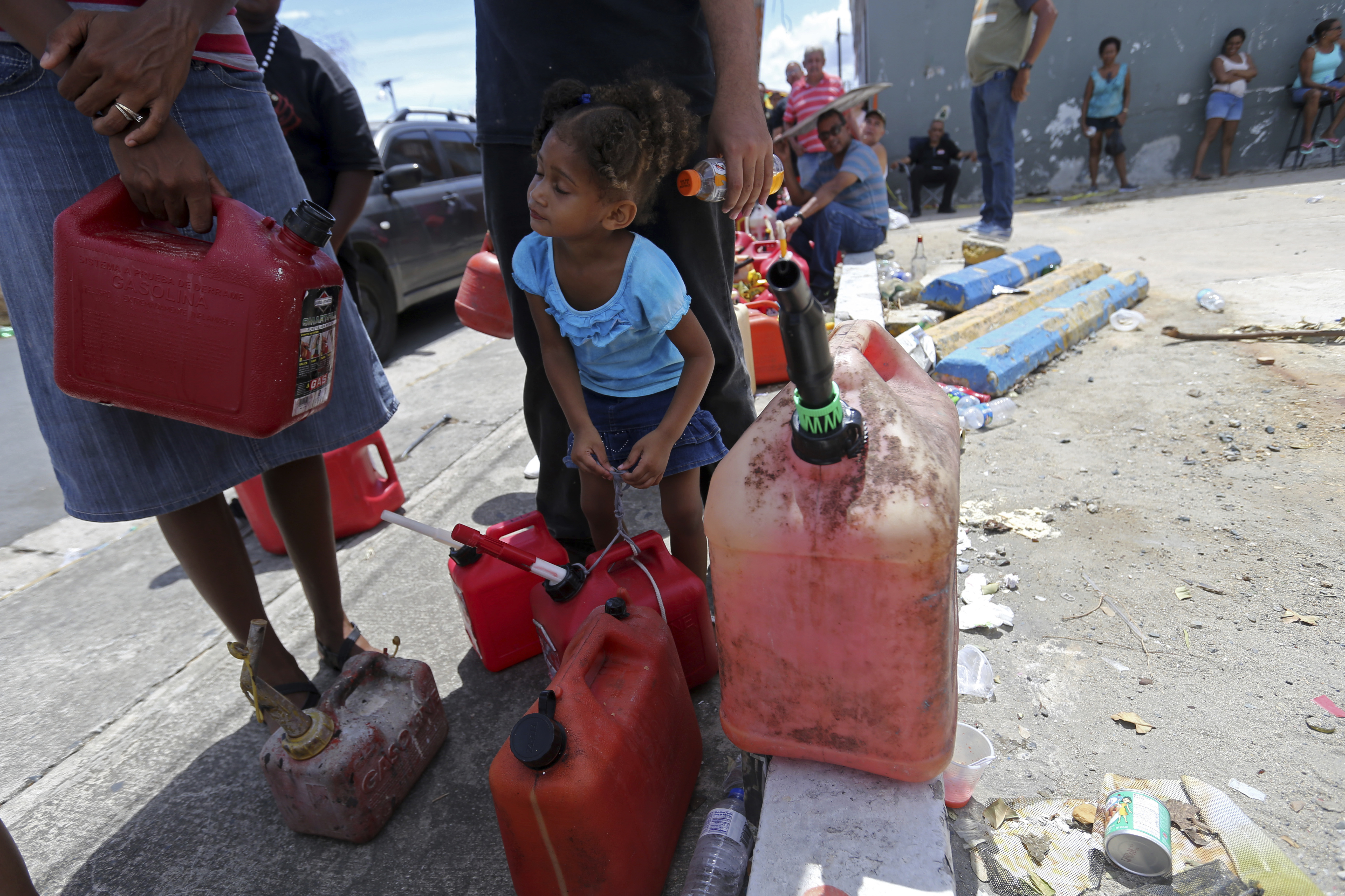 Abi de la Paz de la Cruz, 3, holds a gas can as she waits in line with her family, to get fuel from a gas station, in the aftermath of Hurricane Maria, in San Juan, Puerto Rico, Monday, Sept. 25, 2017. The U.S. ramped up its response Monday to the humanitarian crisis. Photo: AP Photo