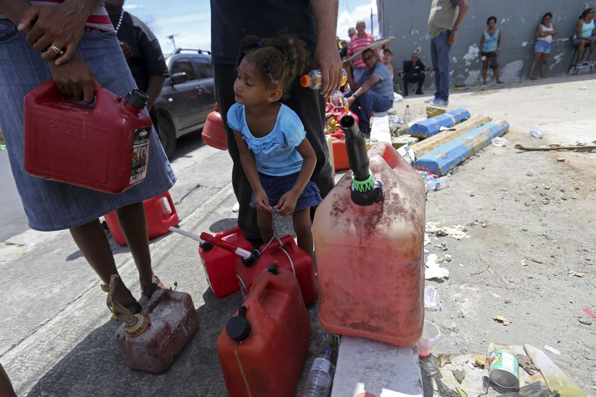 Abi de la Paz de la Cruz, 3, holds a gas can as she waits in line with her family, to get fuel from a gas station, in the aftermath of Hurricane Maria, in San Juan, Puerto Rico, Monday, Sept. 25, 2017. The U.S. ramped up its response Monday to the humanitarian crisis. Photo: AP Photo
