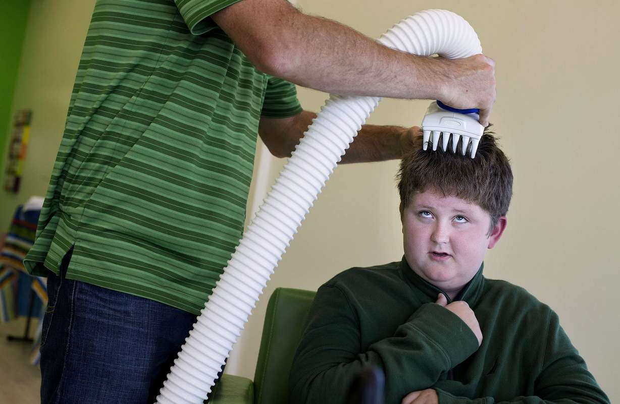 Gabe Pippin, 13, has heat applied to his scalp to treat lice at the grand opening of Lice Clinics of America in Clearfield on Wednesday, Oct. 4, 2017. (Photo: Laura Seitz, KSL)