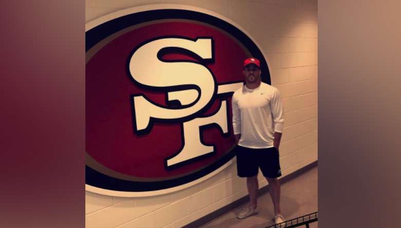 Former SUU punter Brock Miller poses for a photo by a 49ers logo in this undated photo. Miller signed with the San Fransico 49ers in January but was later released. (Photo: Photo Courtesy Brock Miller)