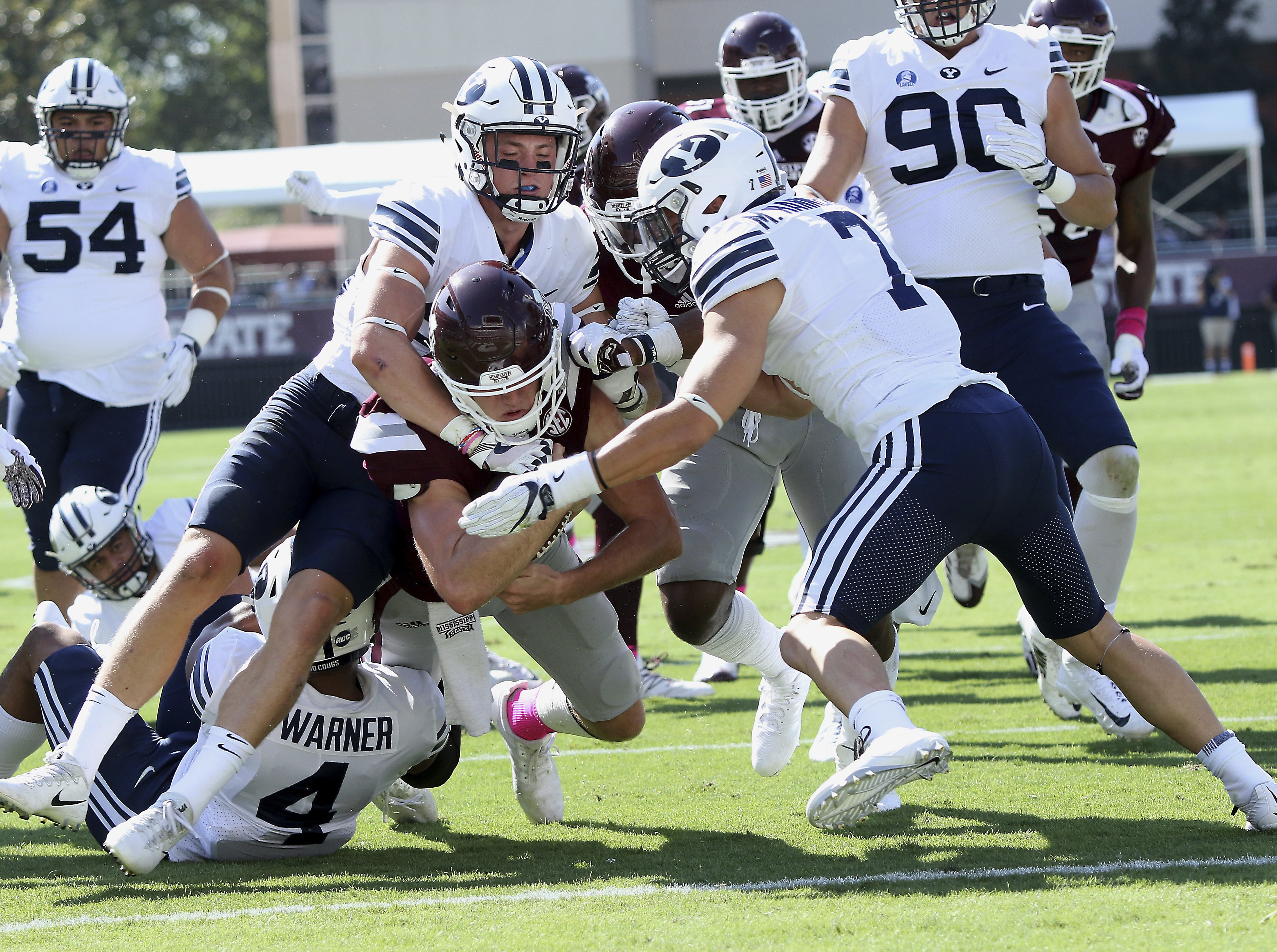 Mississippi State quarterback Nick Fitzgerald, center carries BYU defensive back Zayne Anderson, left, and defensive back Micah Hannemann (7) over the goal line for a touchdown during the first half of an NCAA college football game in Starkville, Miss., Saturday, Oct. 14, 2017. (AP Photo/Jim Lytle)