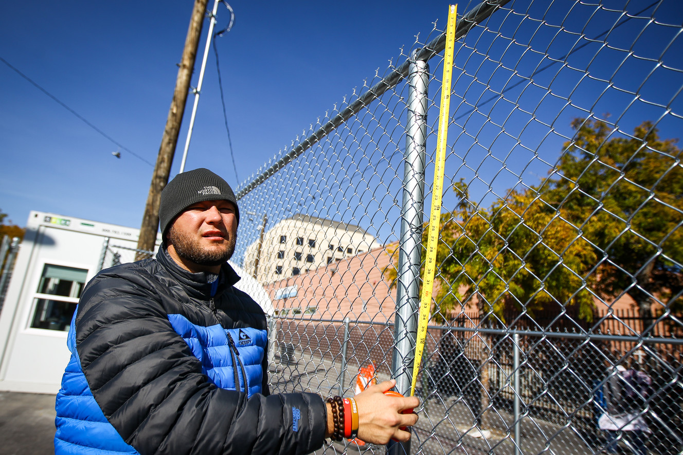 Matt Mellville of Catholic Community Services measures for signs inside the fenced off area on Rio Grande Street in Salt Lake on Monday, Oct. 16, 2017. Rio Grand Street's "safe space" will soon be open to only those who have a DWS-issued ID card. (Photo: Adam Fondren, Deseret News)