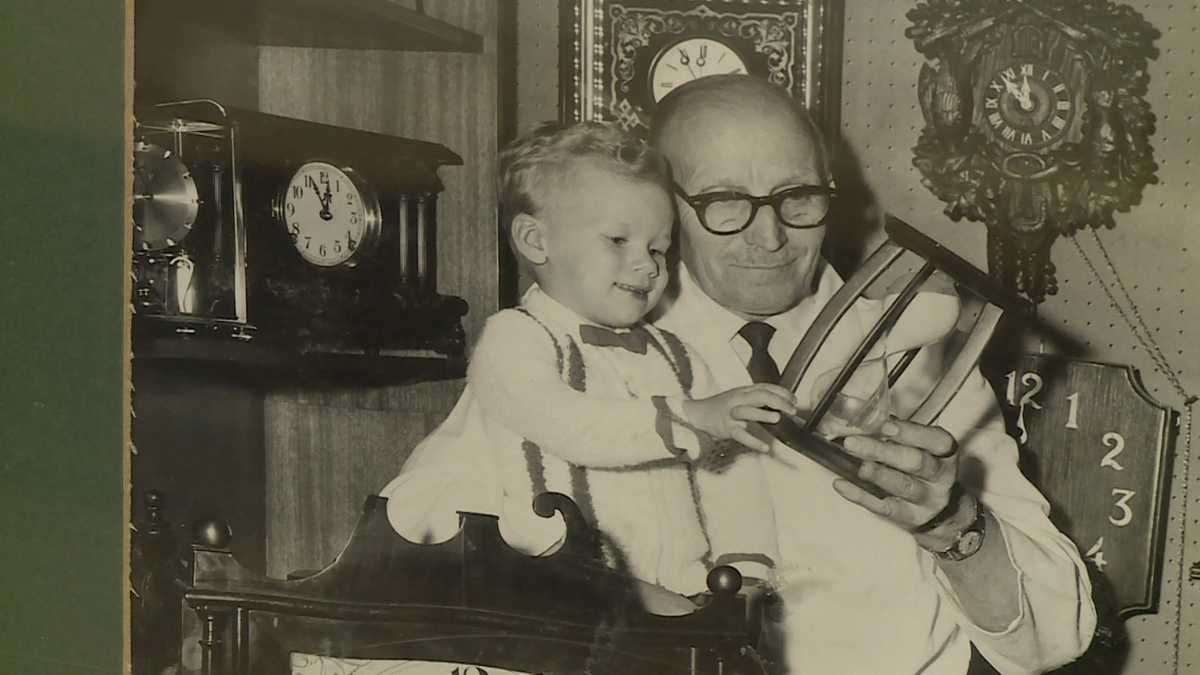 Heinrich Recksick poses for a photo with a child. He and his brother, Werner, founded the Mt. Olympus Clock Shop. (Photo: Ray Boone, KSL)