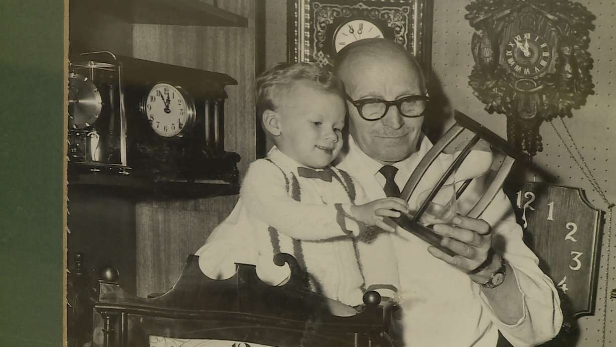 Heinrich Recksick poses for a photo with a child. He and his brother, Werner, founded the Mt. Olympus Clock Shop. (Photo: Ray Boone, KSL)