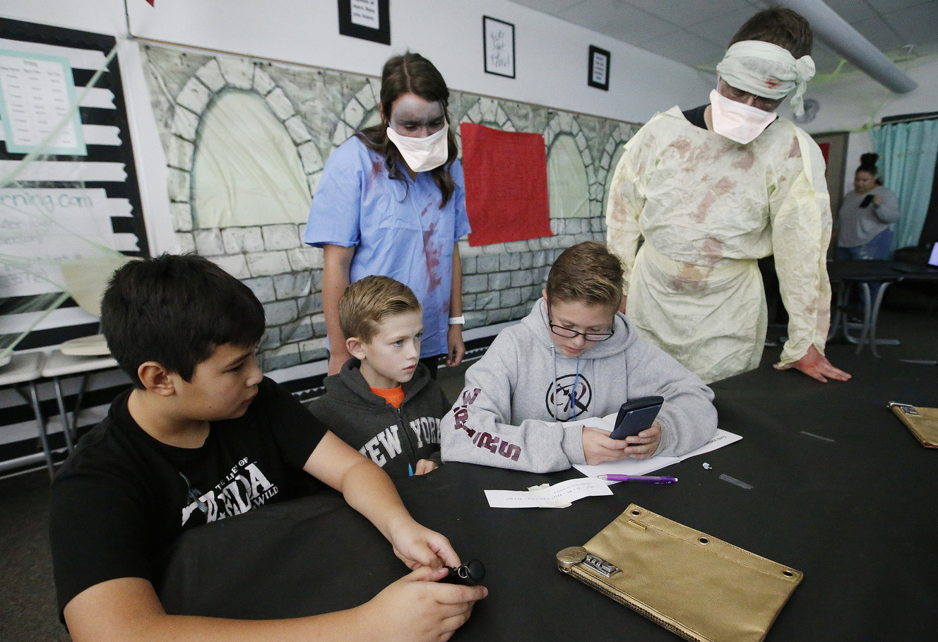 West Point Junior High students Jaden Crane, Caleb Miller and Dallin Burrell work to solve math problems to “escape zombies” in West Point on Tuesday, Oct. 31, 2017. (Photo: Jeffrey D. Allred, KSL)