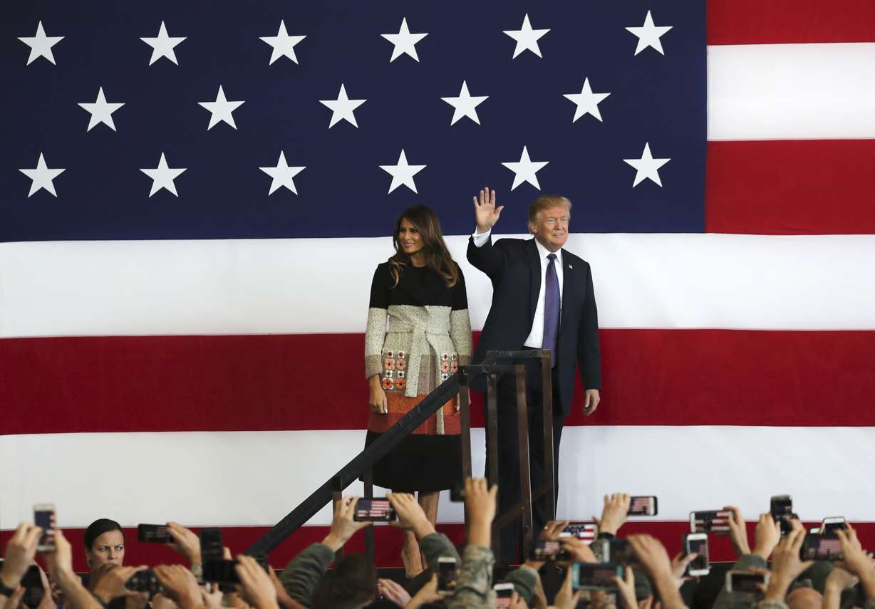 U.S. President Donald Trump, right, with first lady Melania Trump, waves to the U.S. troops at the U.S. Yokota Air Base, on the outskirts of Tokyo, Sunday, Nov. 5, 2017. President Trump arrived in Japan Sunday on a five-nation trip to Asia, his second extended foreign trip since taking office and his first to Asia. The trip will take him to Japan, South Korea, China, Vietnam and Philippines for summits of the Asia-Pacific Economic Cooperation (APEC) and the Association of Southeast Asian Nations (ASEAN). (AP Photo/Eugene Hoshiko)