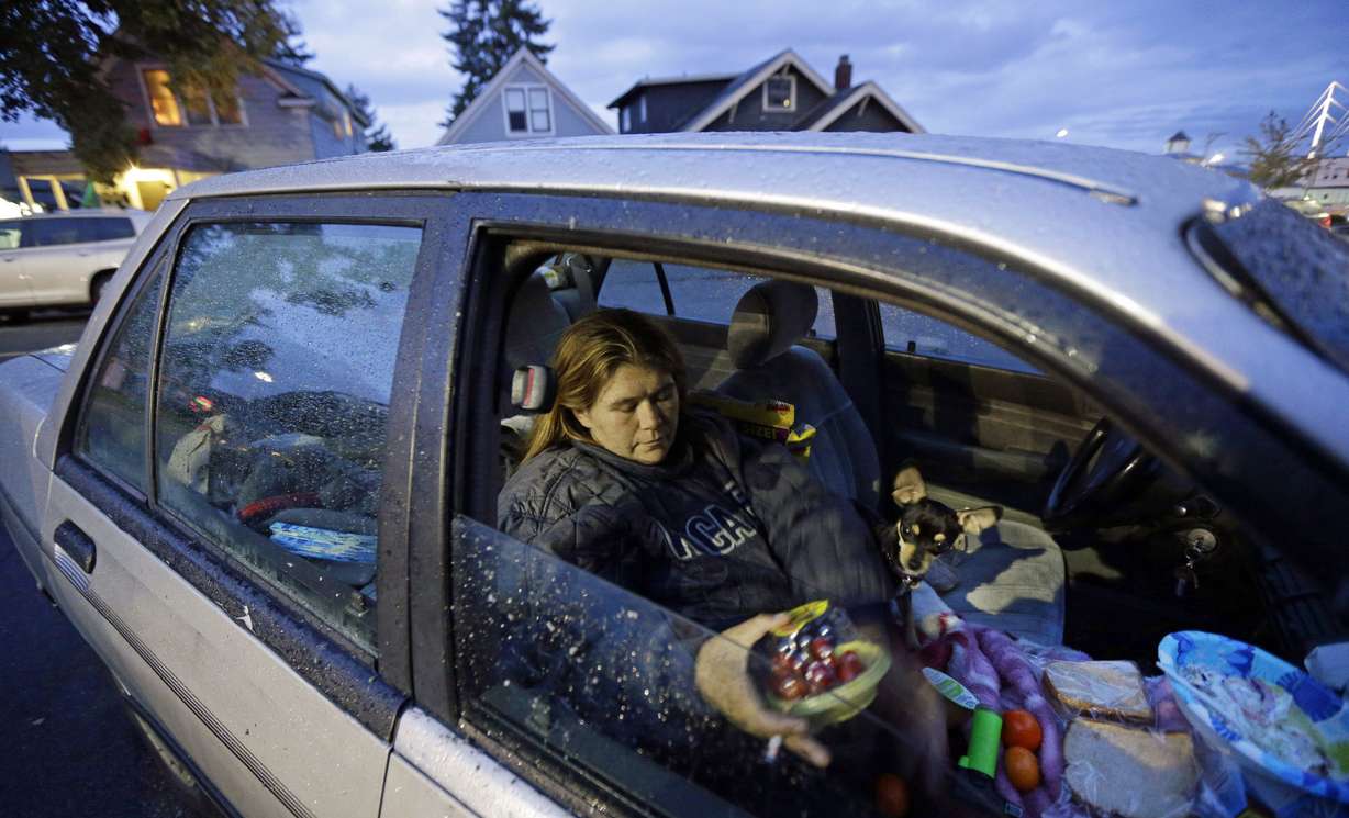 Paige Clem sits in the car she lives in along with her husband and three dogs outside a church where free food was being distributed in Everett, Wash. Photo: AP Photo