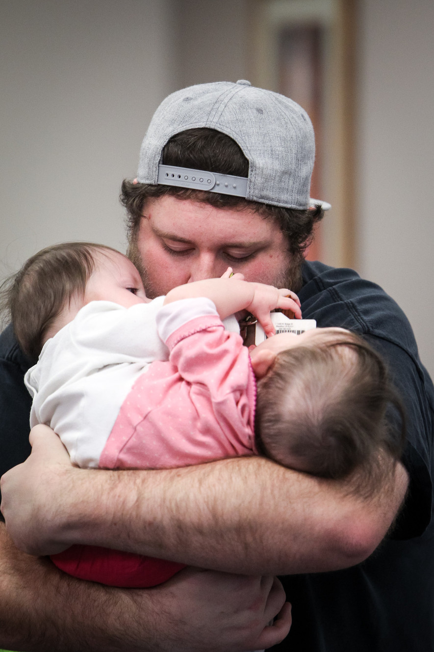 Nick Torres hugs his daughters Carter, left, and Callie at the Utah Center for Assistive Technology in Salt Lake City on Monday, Nov. 6, 2017. The center fitted the conjoined twins for a specialized baby jumper. The girls share a single set of legs and their organs from the belly button downward. (Photo: Adam Fondren, KSL)