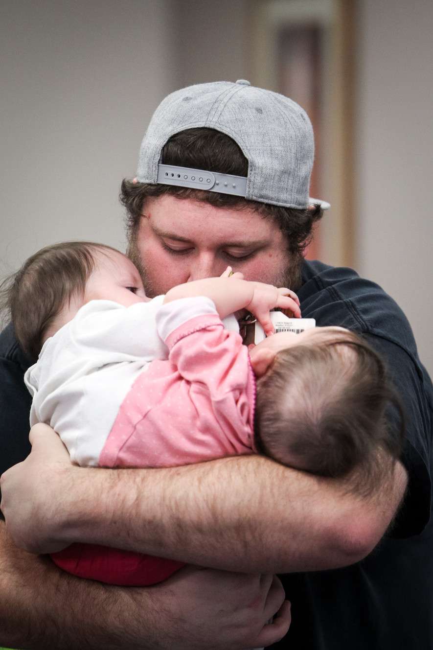 Nick Torres hugs his daughters Carter, left, and Callie at the Utah Center for Assistive Technology in Salt Lake City on Monday, Nov. 6, 2017. The center fitted the conjoined twins for a specialized baby jumper. The girls share a single set of legs and their organs from the belly button downward. (Photo: Adam Fondren, KSL)