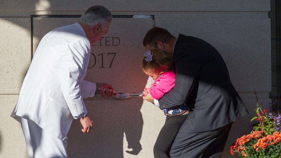 A girl manages the trowel with the help of her father and President Dieter F. Uchtdorf for the job of placing mortar around the cornerstone of the Meridian Idaho Temple, Sunday, Nov. 19, 2017. Photo: Intellectual Reserve Inc.